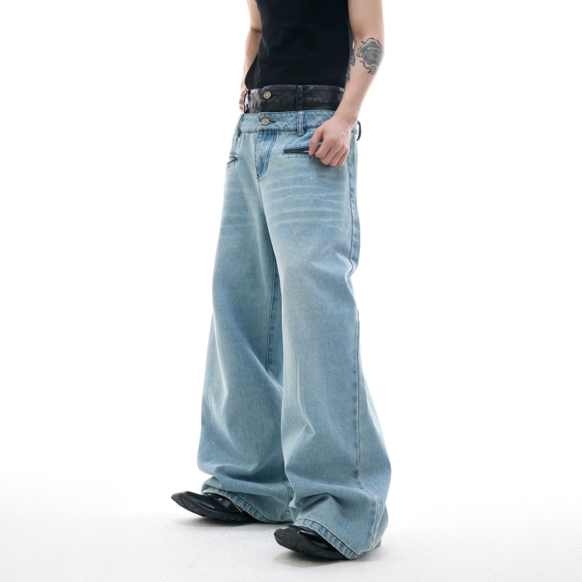 Close up of double waistband detail on baggy washed denim jeans