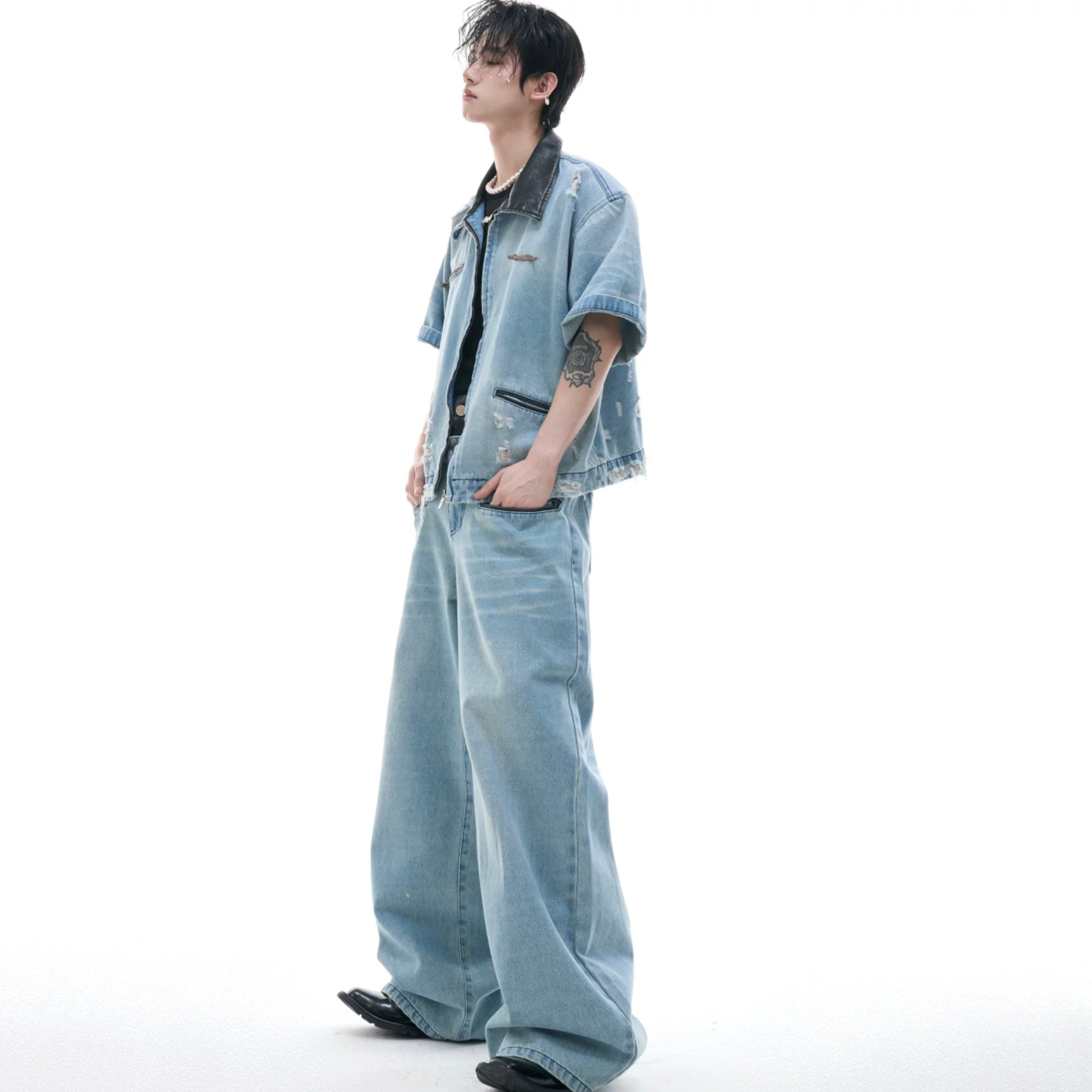 Model wearing the full blue washed distressed denim set in a street setting