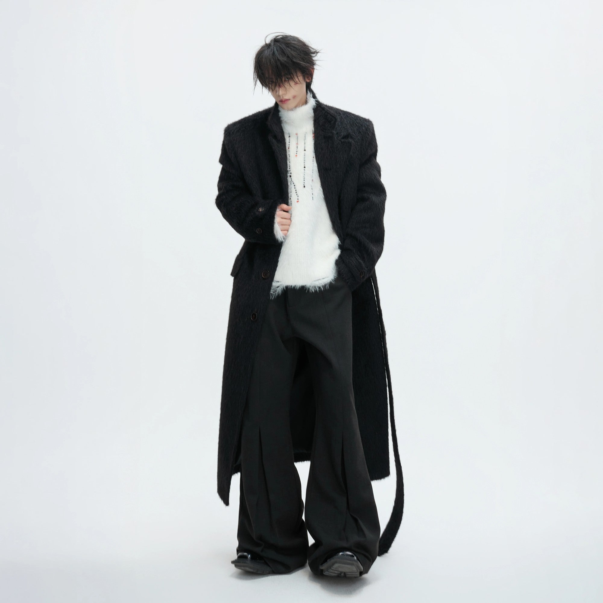 Detailed shot of the embroidery and distressing on a black mohair sweater