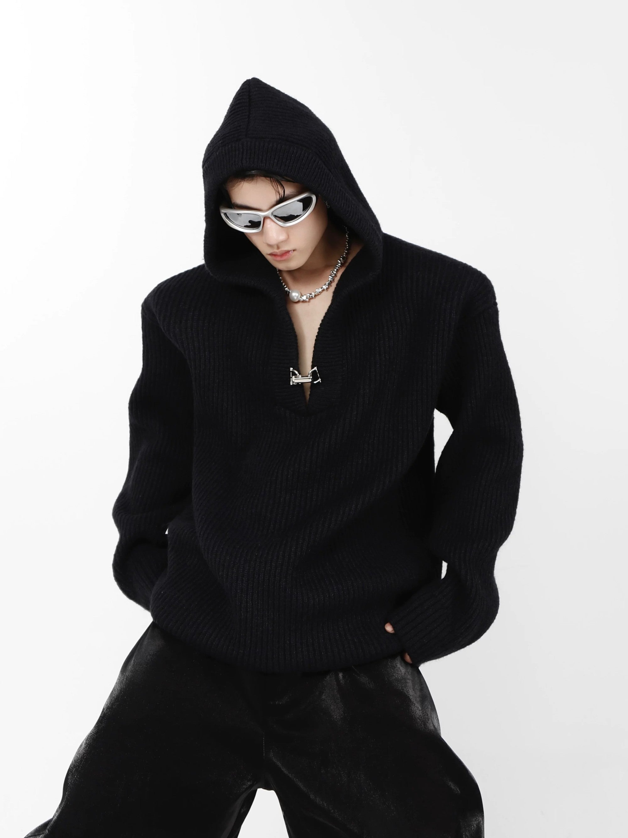 Model wearing a minimalist oversized knit hoodie in a street setting