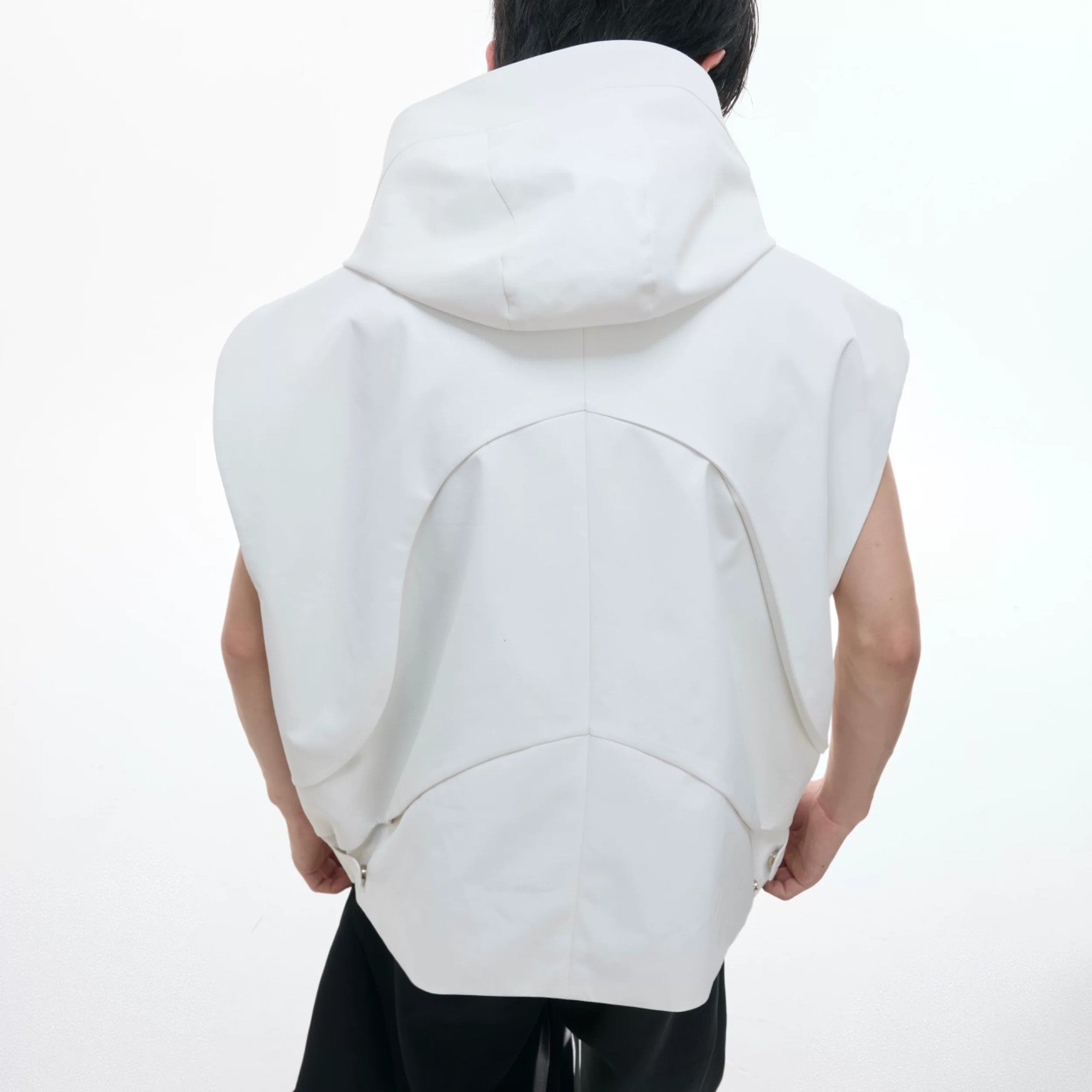 Model wearing white sleeveless hooded vest set in urban street setting