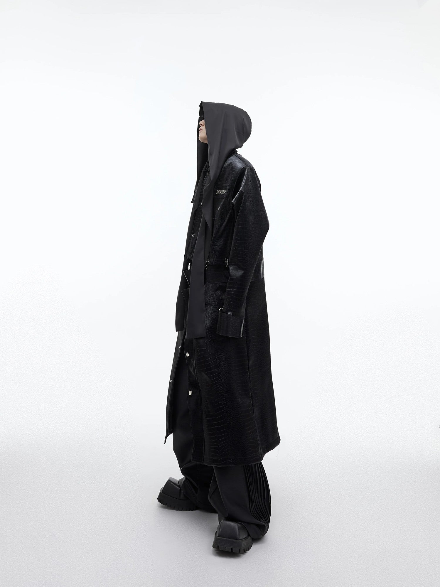 Model wearing oversized black hooded shirt in a city street setting