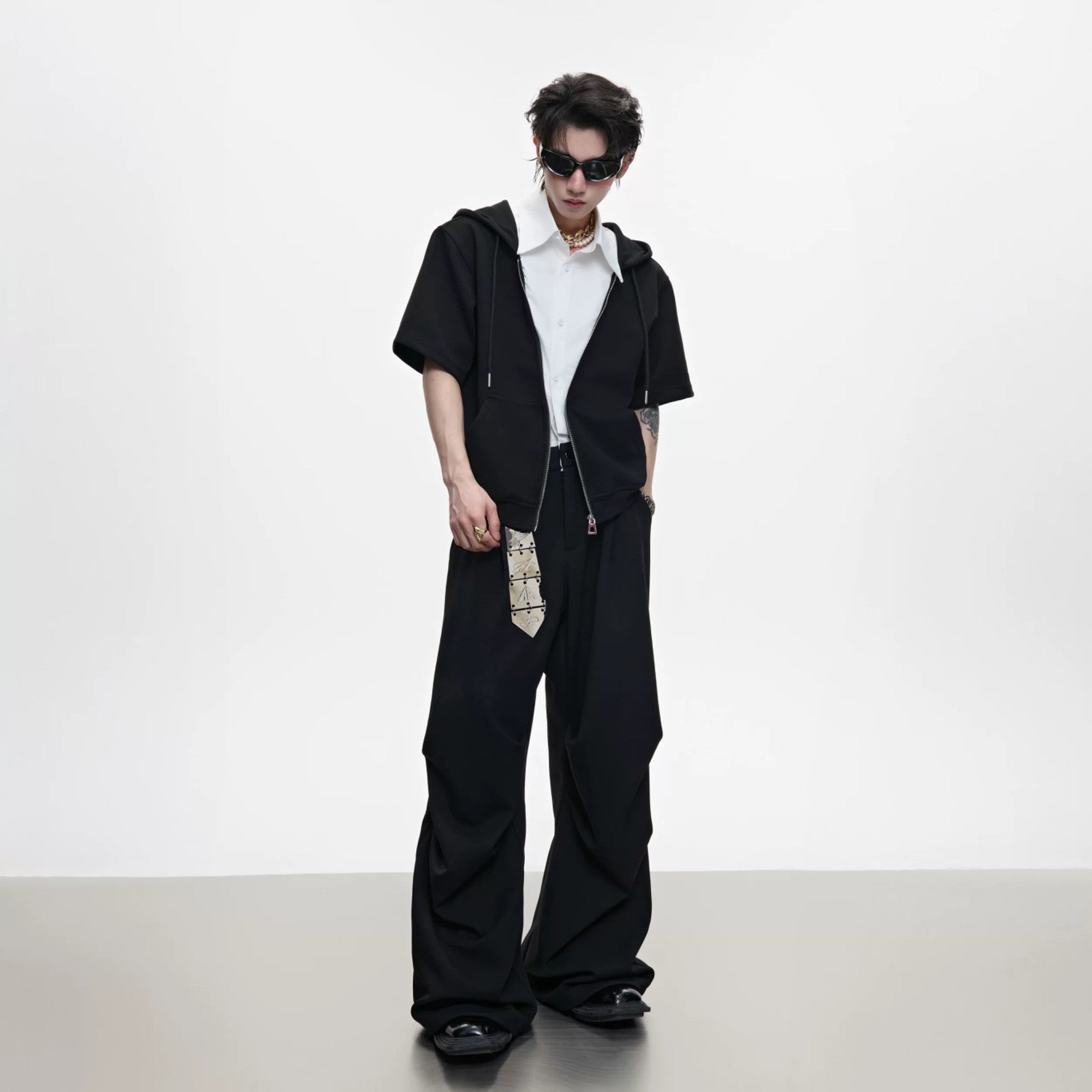 Model wearing black deconstructed hoodie set in urban street setting