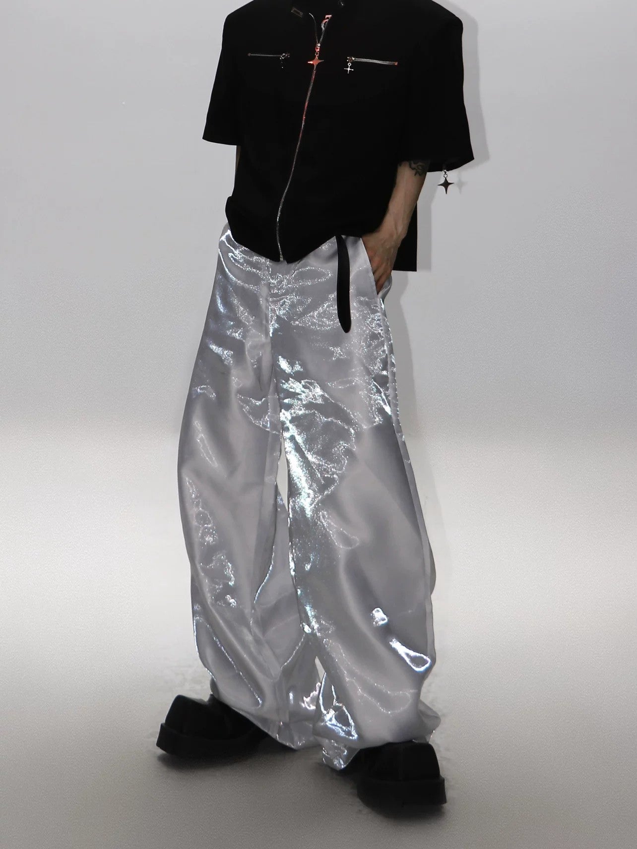 Model wearing liquid silver pants in a city street setting
