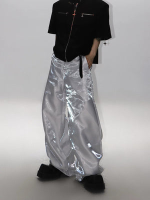 Model wearing liquid silver pants in a city street setting