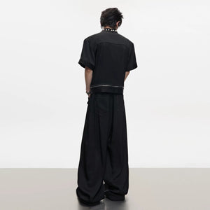 Close-up of oversized pearl accents on the denim shirt collar