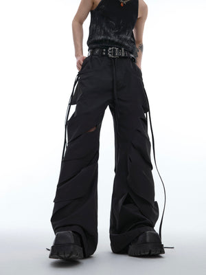 Side angle showing asymmetrical pleats and strategic distressing on these fashion-forward cargo pants