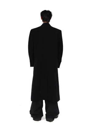 Back view showing unique tailoring of wool coat with pronounced shoulder pads and contemporary silhouette