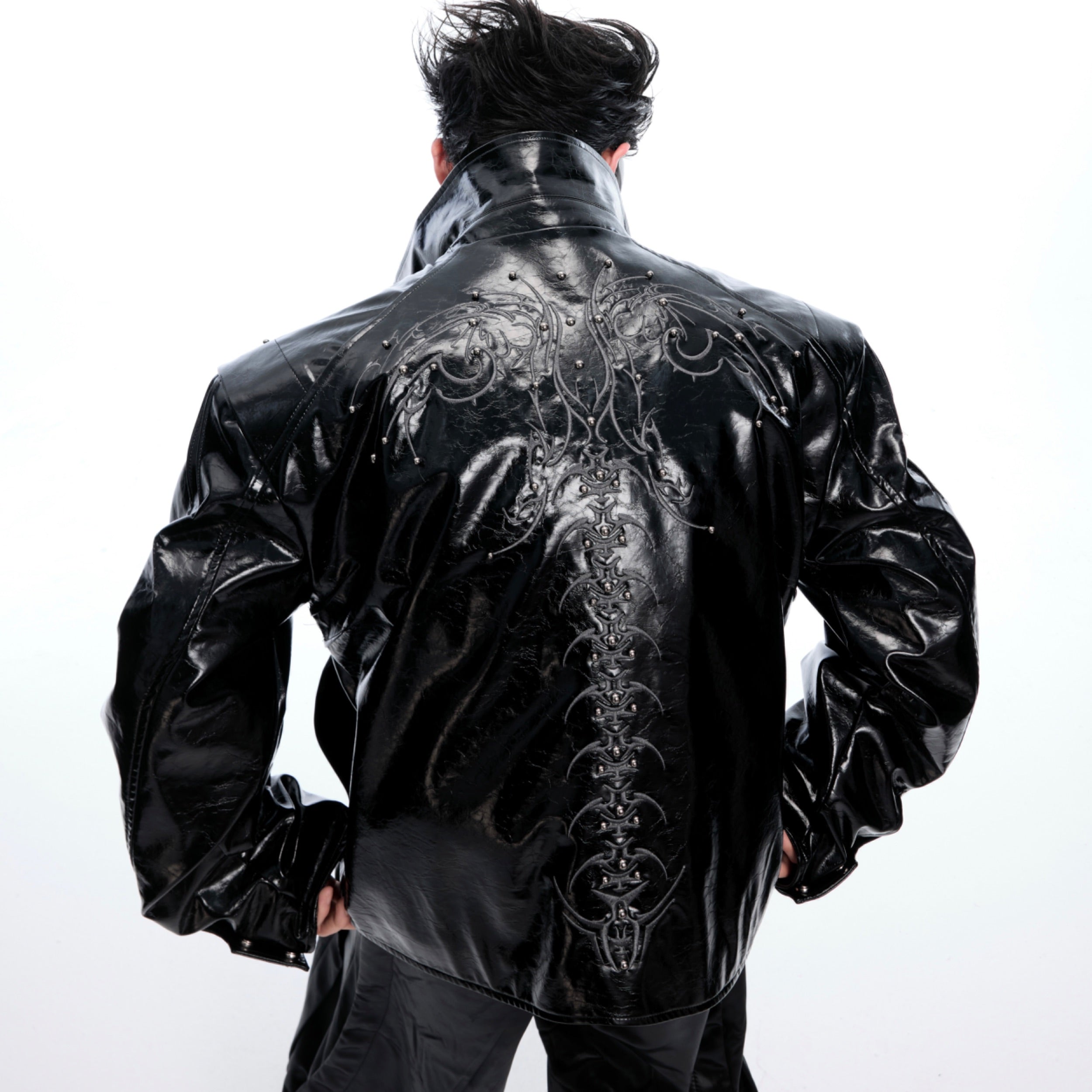 Close-up of premium quality spiked embellishments and embossed leather texture on streetwear coat
