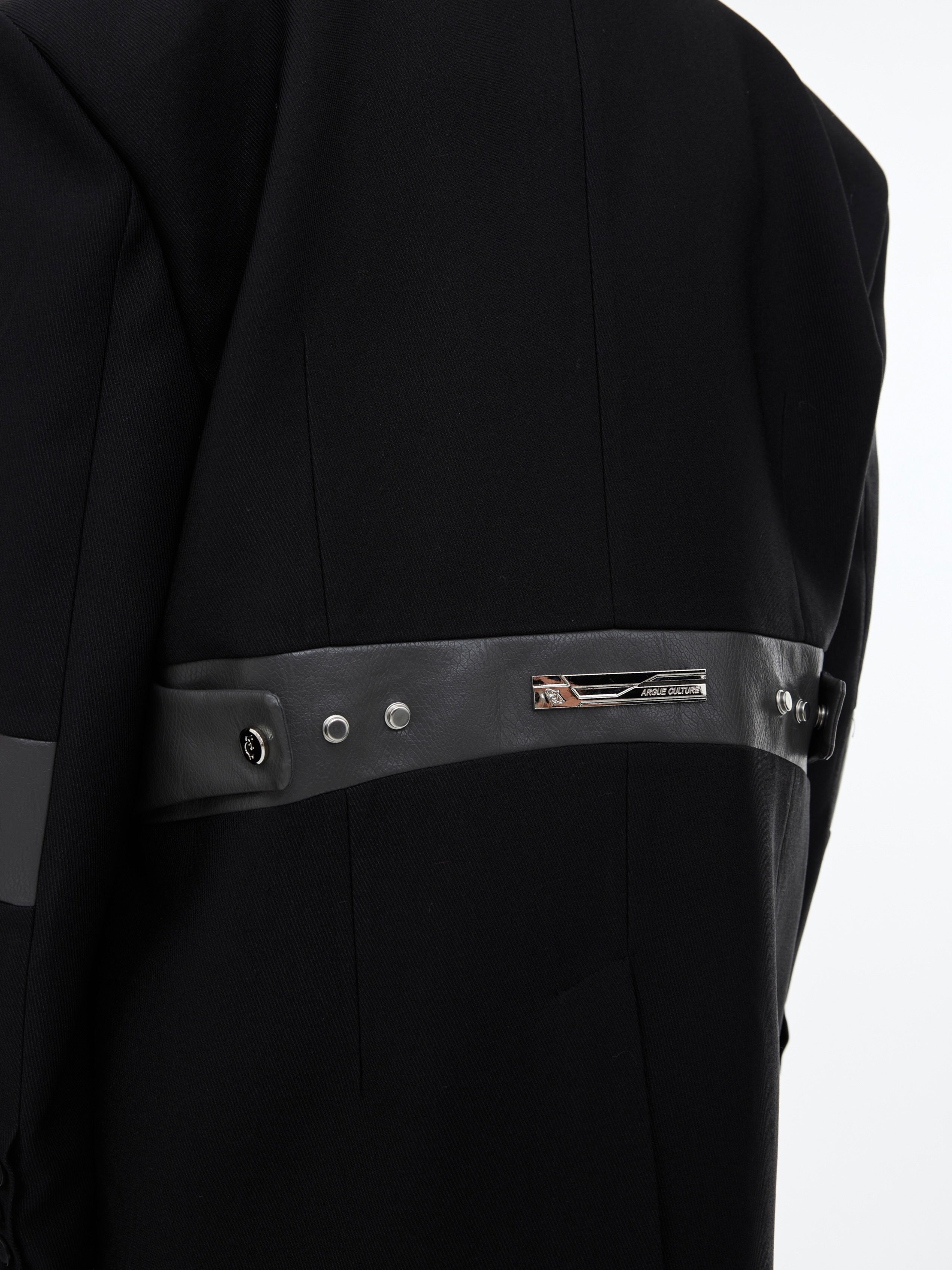 Side profile of avant-garde streetwear blazer showcasing equestrian-inspired lines and dimensional pleating