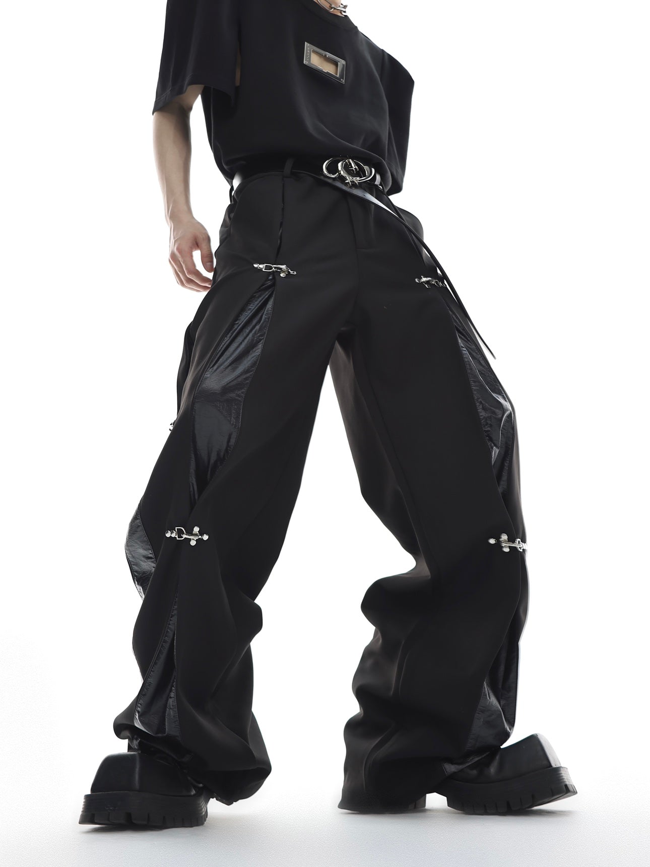 Front view of deconstructed cargo pants featuring leather patches and straight leg streetwear design