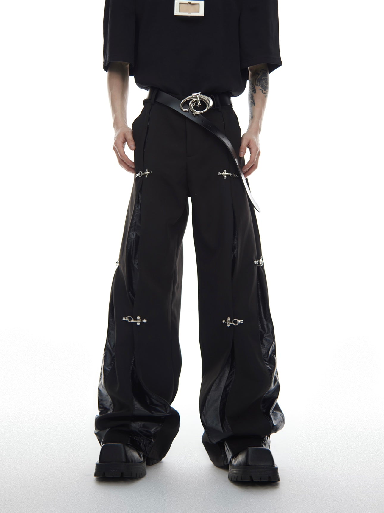 Detailed shot showing the metal hardware and deconstructed elements on streetwear cargo trousers