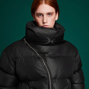 Stylish model wearing the oversized high-neck puffer jacket with diagonal zipper in urban setting