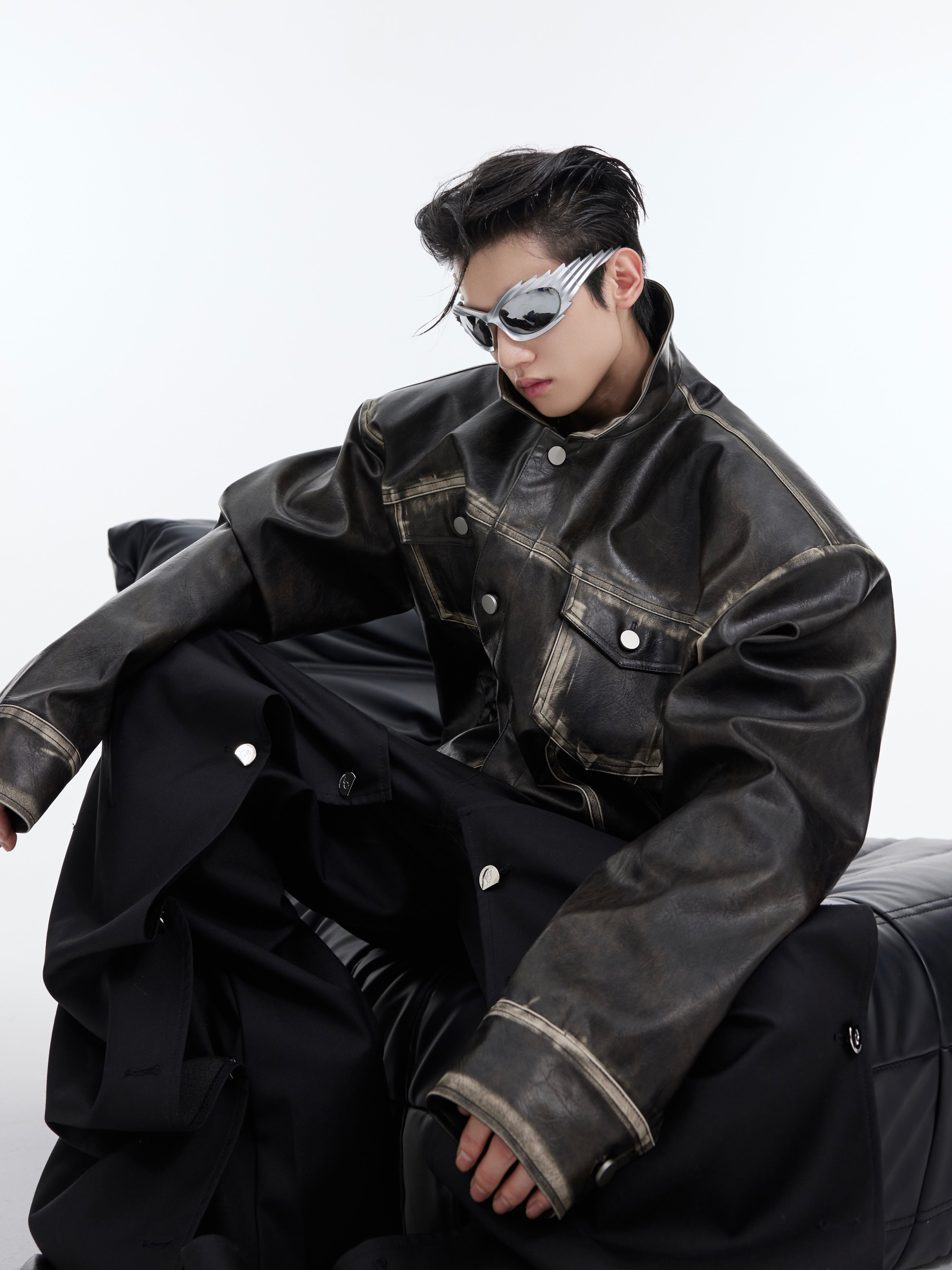 Detail shot showing metal hardware and stitching on vintage style cropped leather motorcycle jacket