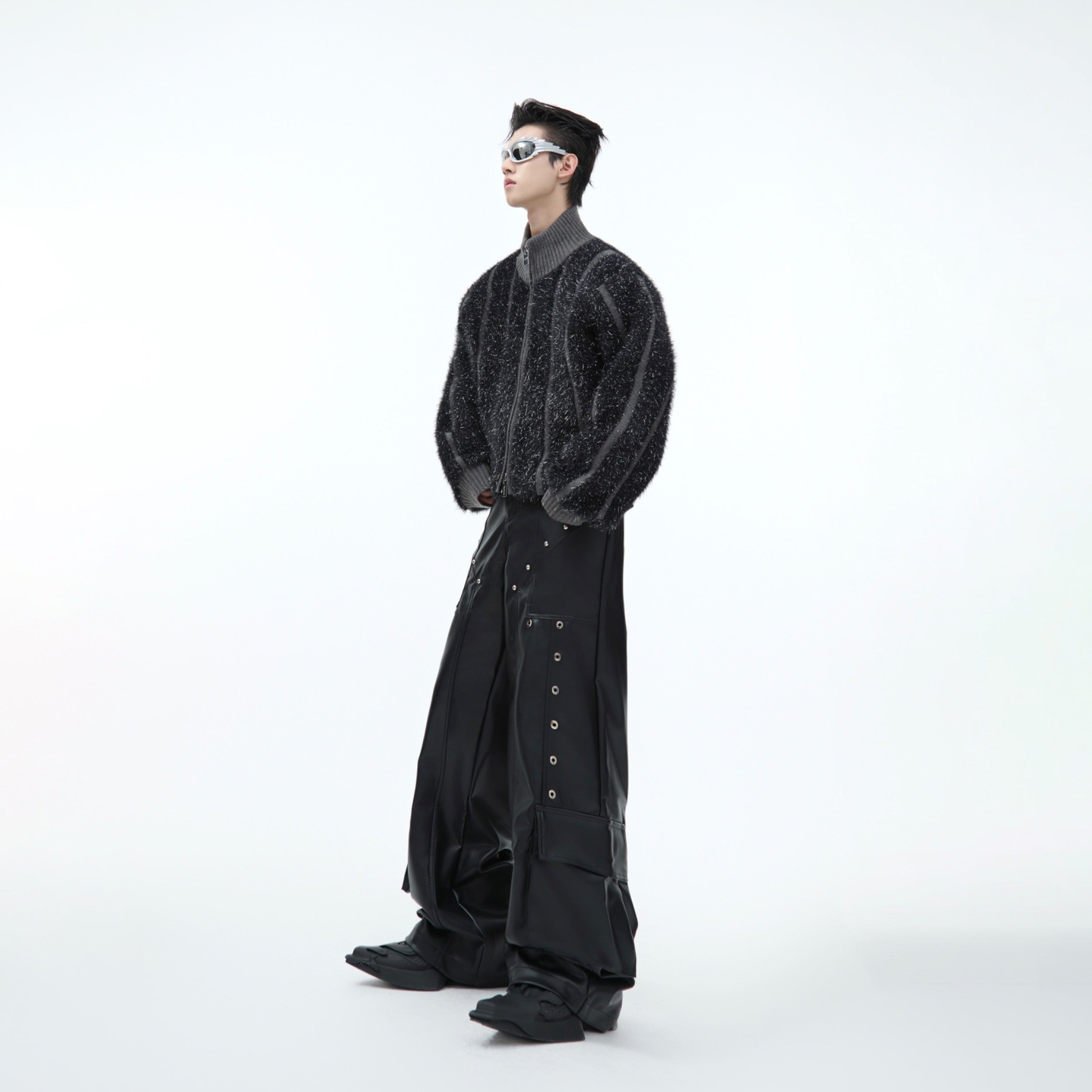 Back view of fashion model wearing statement silver glitter knit coat with high neck design