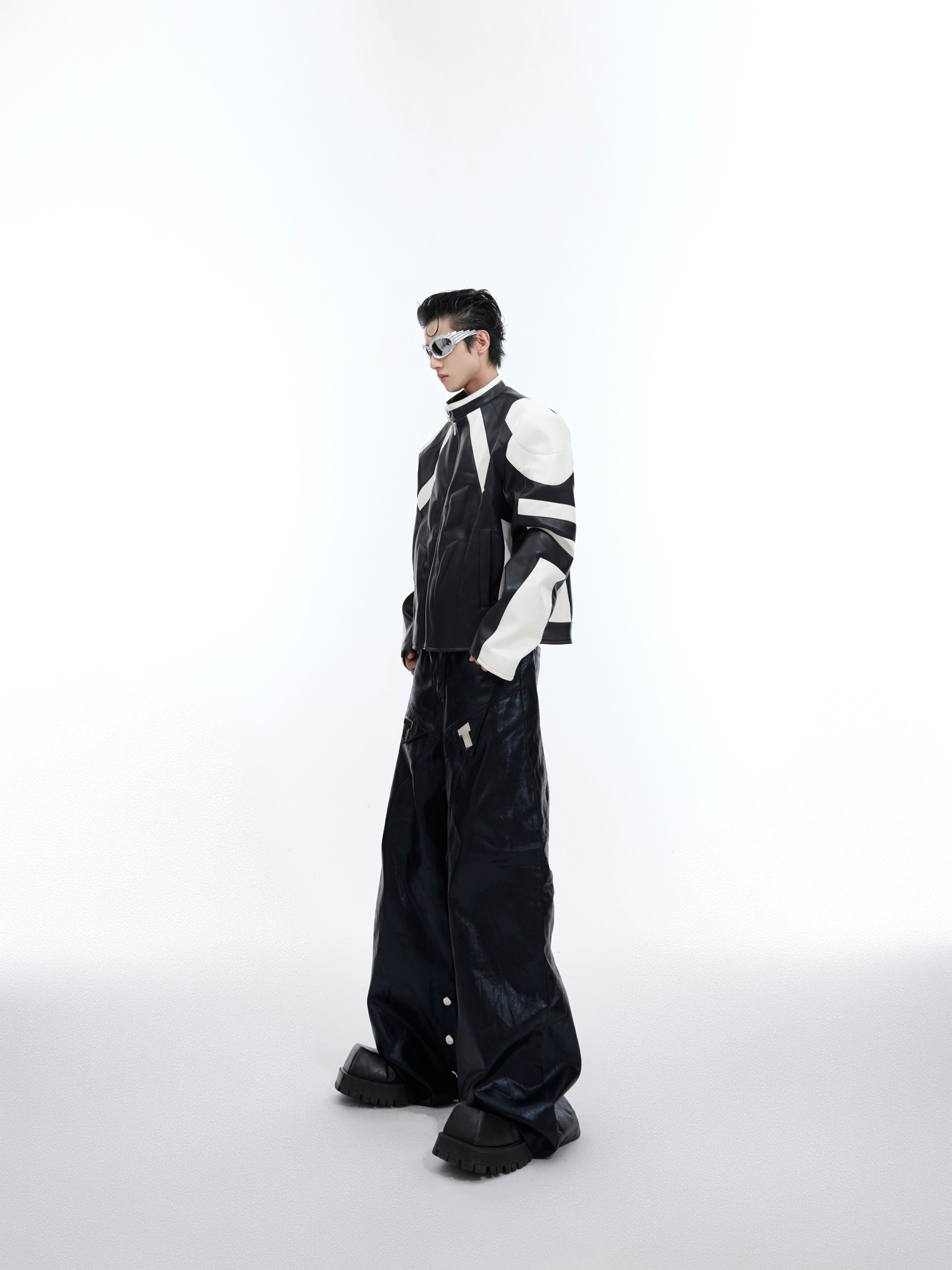 Model wearing deconstructed color-block jacket demonstrating the cropped streetwear silhouette