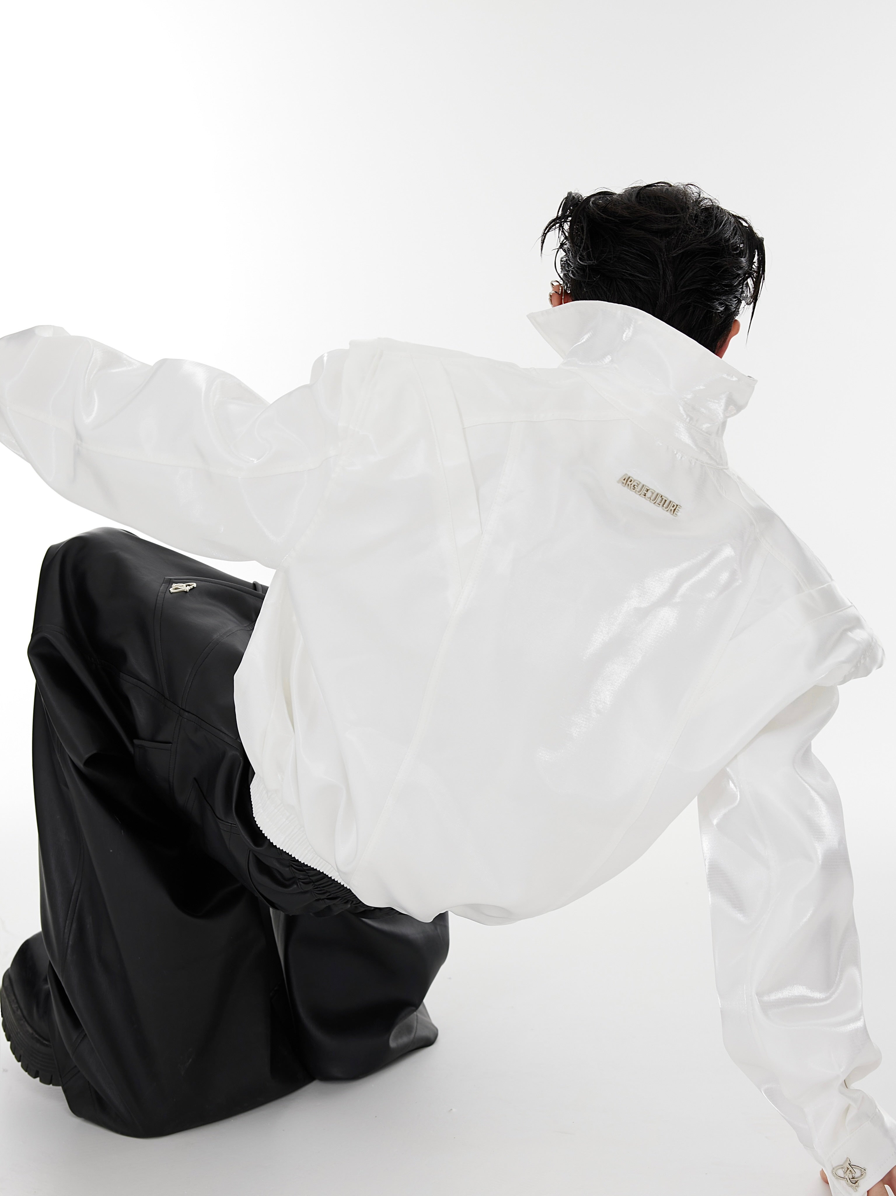 Fashion-forward cropped leather jacket with liquid-like silhouette and statement-making deconstructed shoulders
