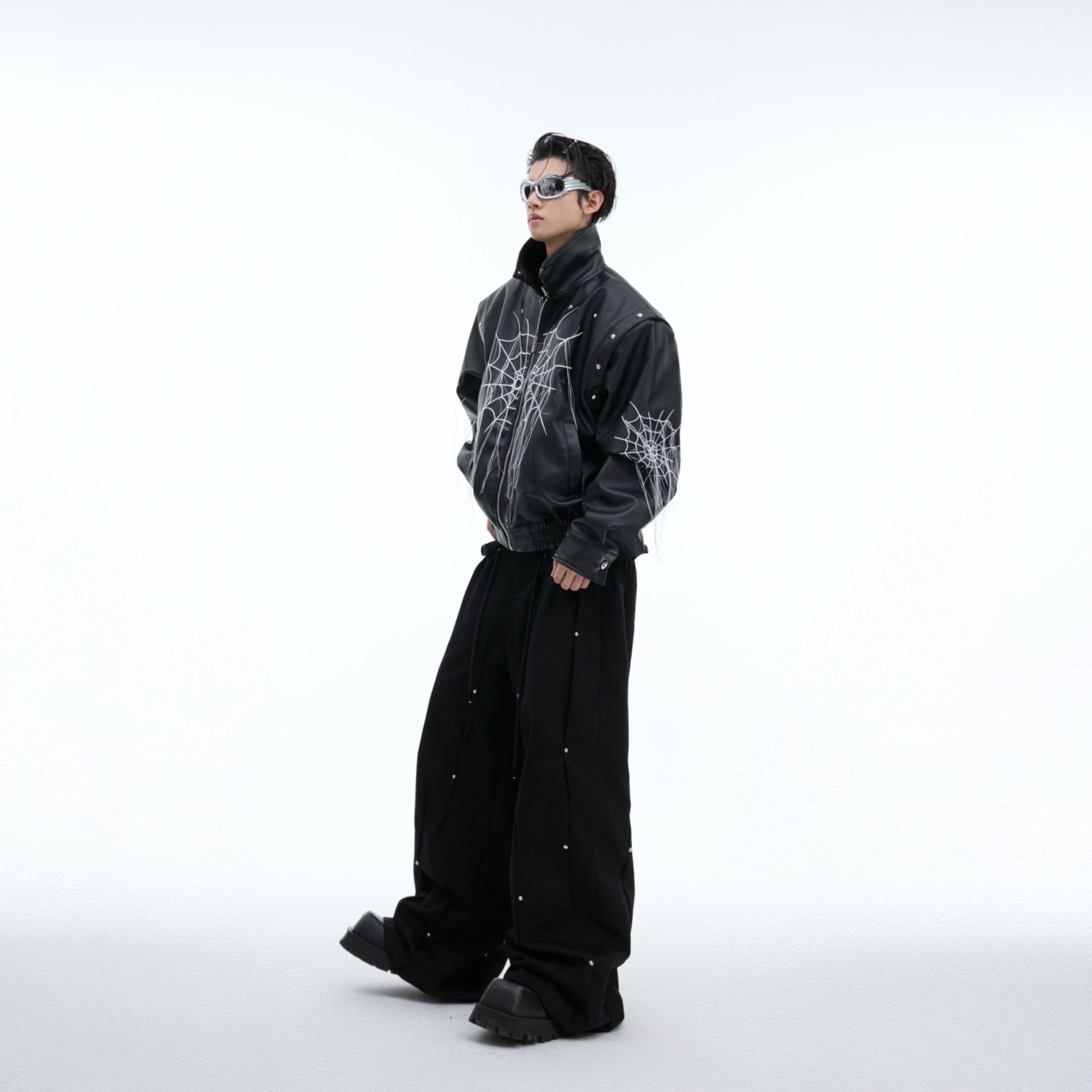 Side angle shot of avant-garde leather jacket with oversized silhouette and distressed punk aesthetic