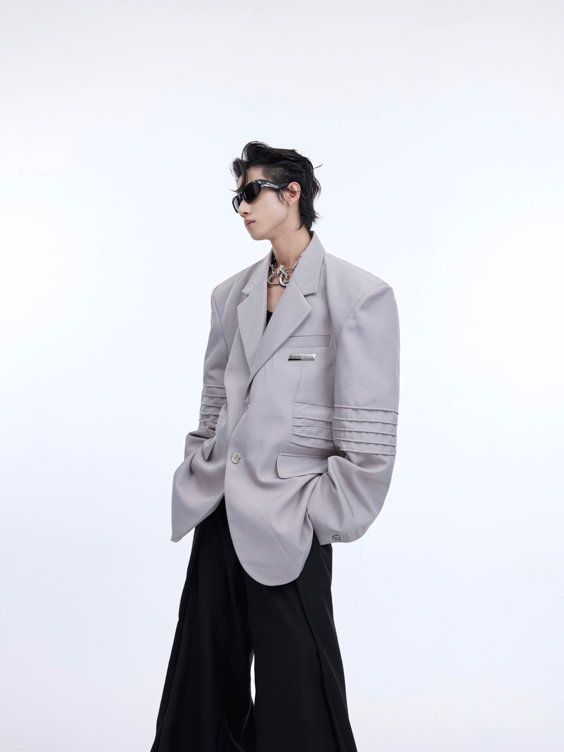 Front view of slim fit deconstructed blazer with liquid-shine fabric and asymmetrical paneling for streetwear style