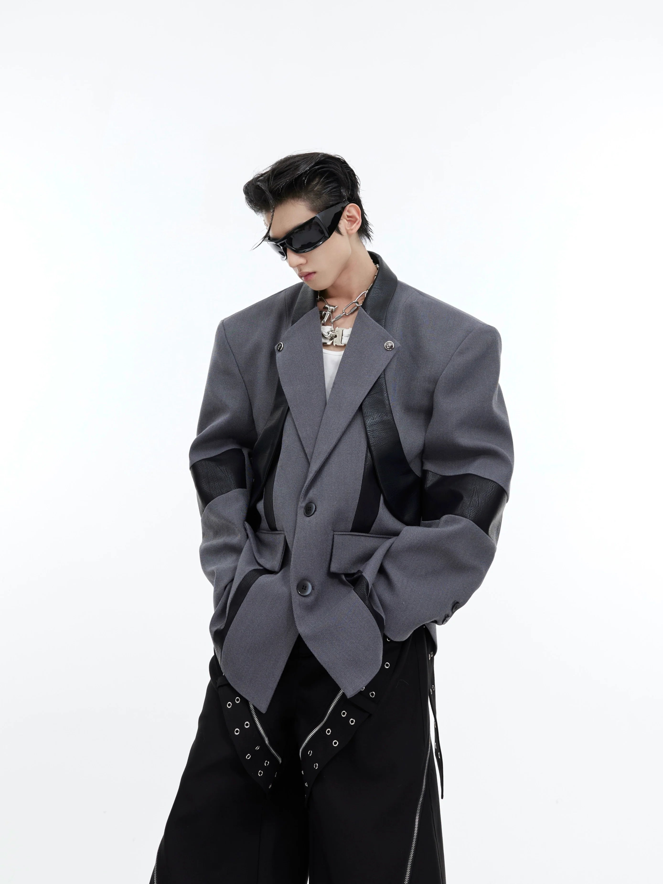 Front view of deconstructed shoulder-pad blazer with metallic detailing, showing asymmetrical patchwork design
