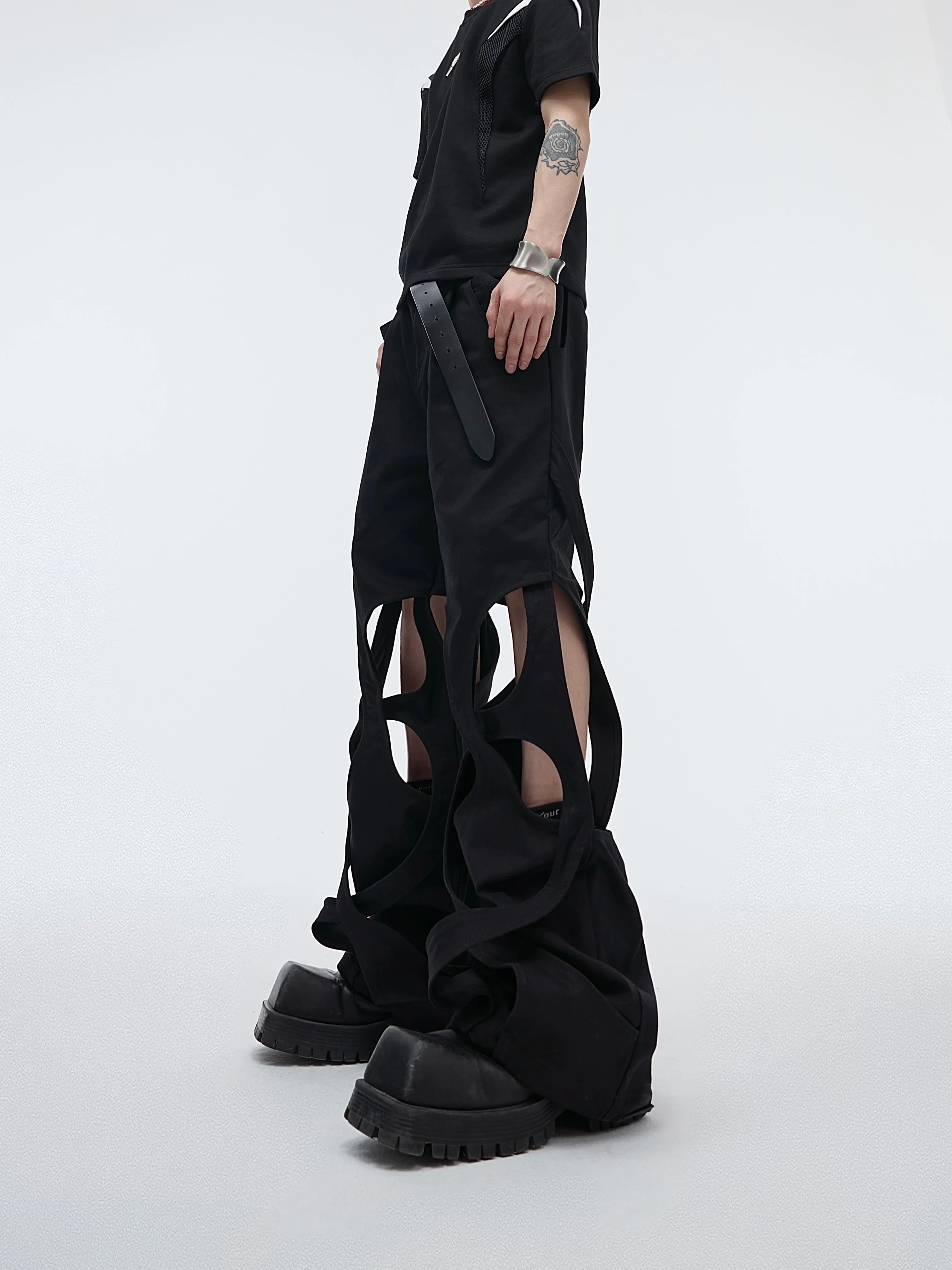 Distressed deconstructed cargo pants with unique hollow-out details, showcasing the edgy streetwear design