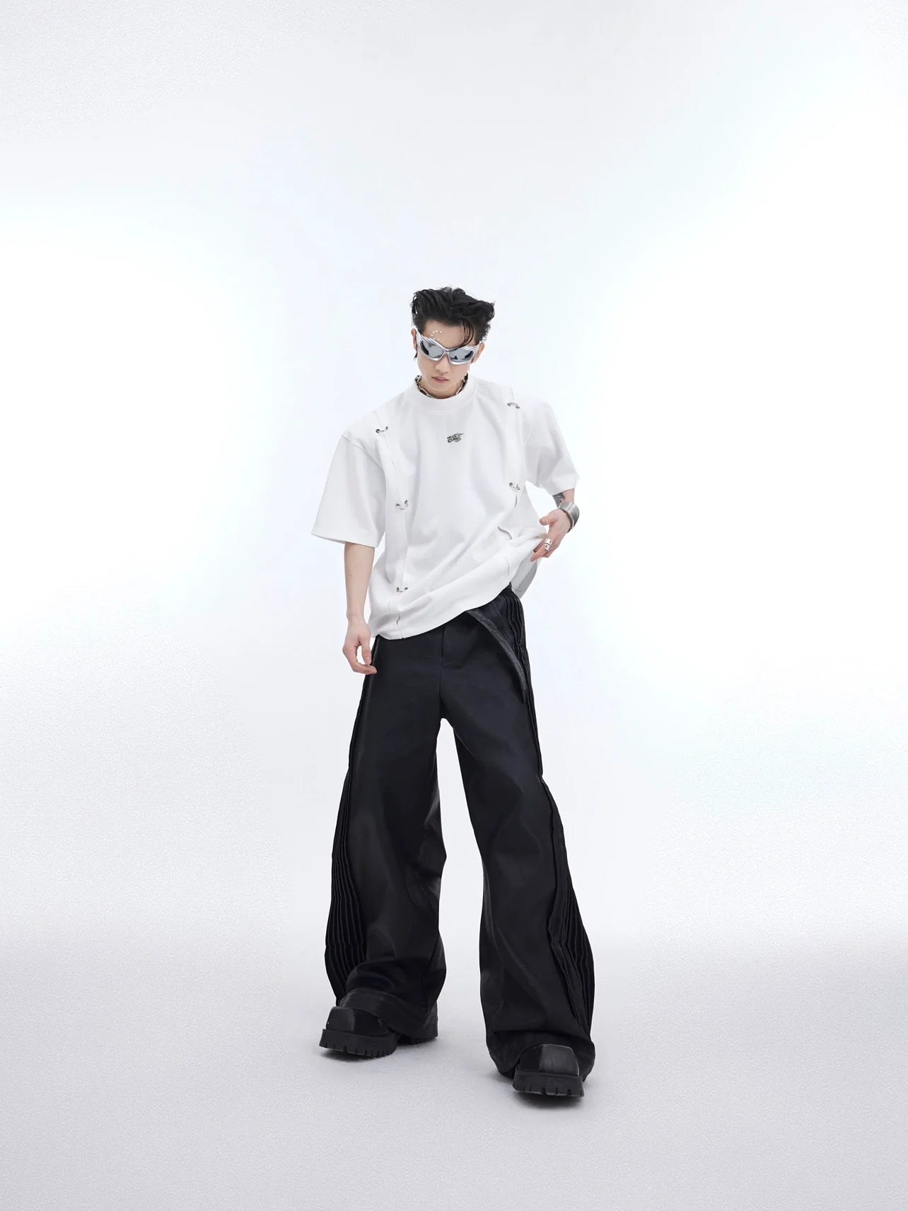 Deconstructed streetwear tee with asymmetric round-hole cutouts and metal detailing, oversized drop-shoulder design