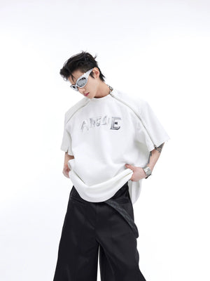 Front view of deconstructed oversized tee with metal trim and drop shoulder, showcasing urban streetwear style