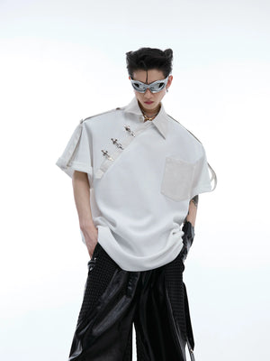 Close-up of unique metal grommet detailing on deconstructed polo shirt with split shoulder design and PU leather trim