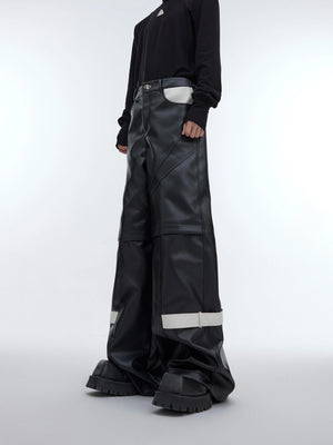 Front view of avant-garde deconstructed leather pants with bold geometric cutouts and belt detailing