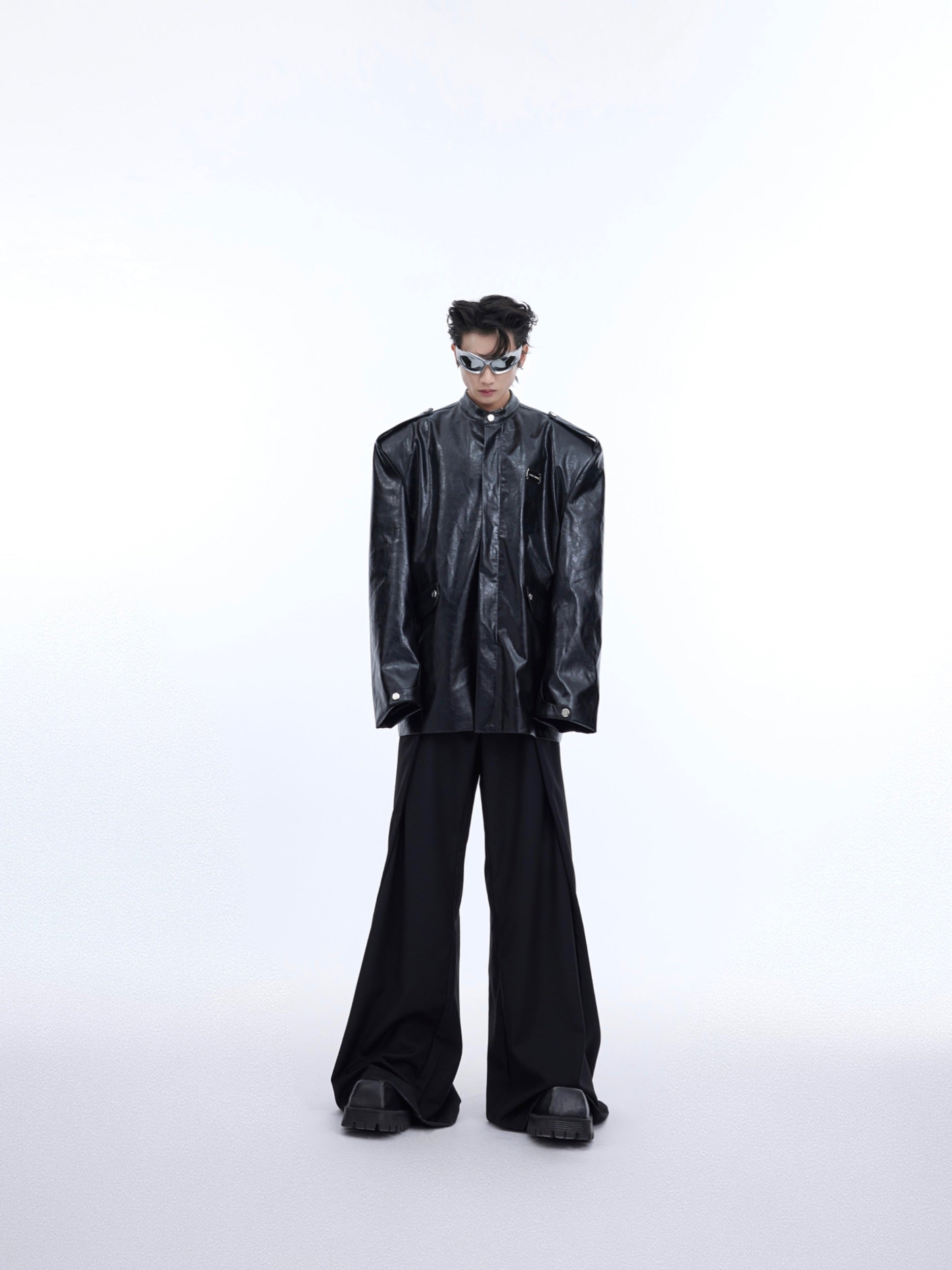 Side angle of deconstructed shiny leather jacket highlighting the unique textured segmentation and modern tailoring