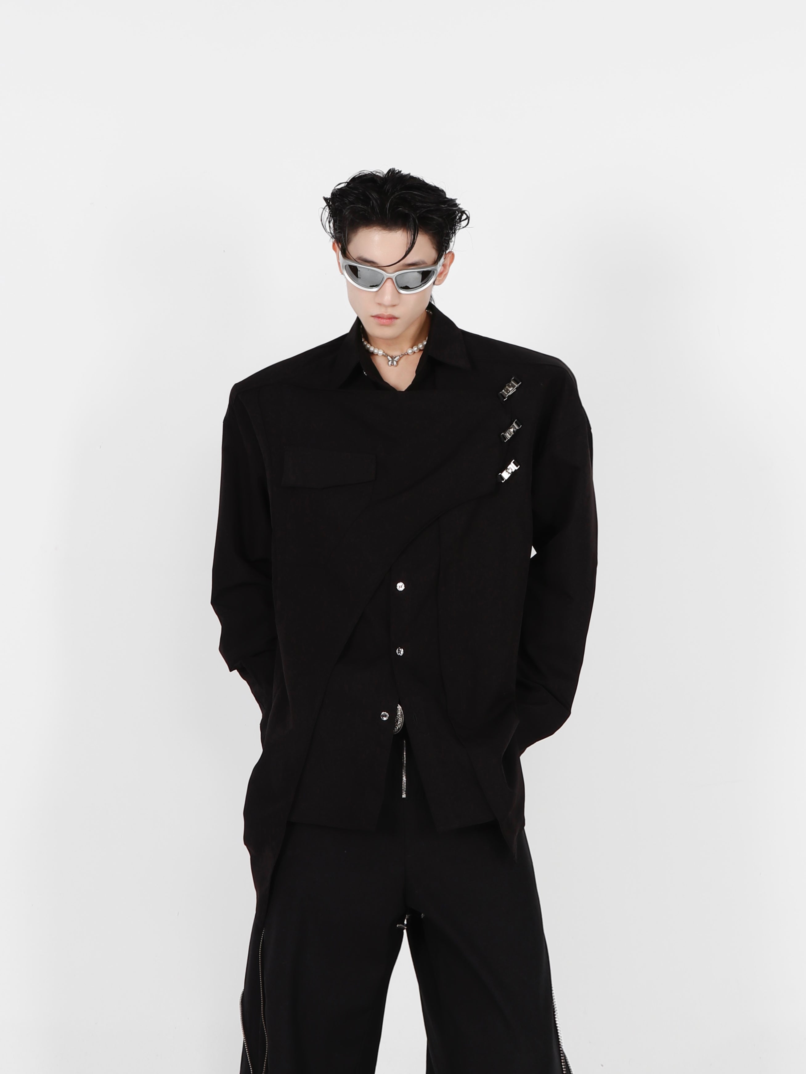 Close-up of the deconstructed shoulder pad and metal detailing on this long sleeve streetwear shirt