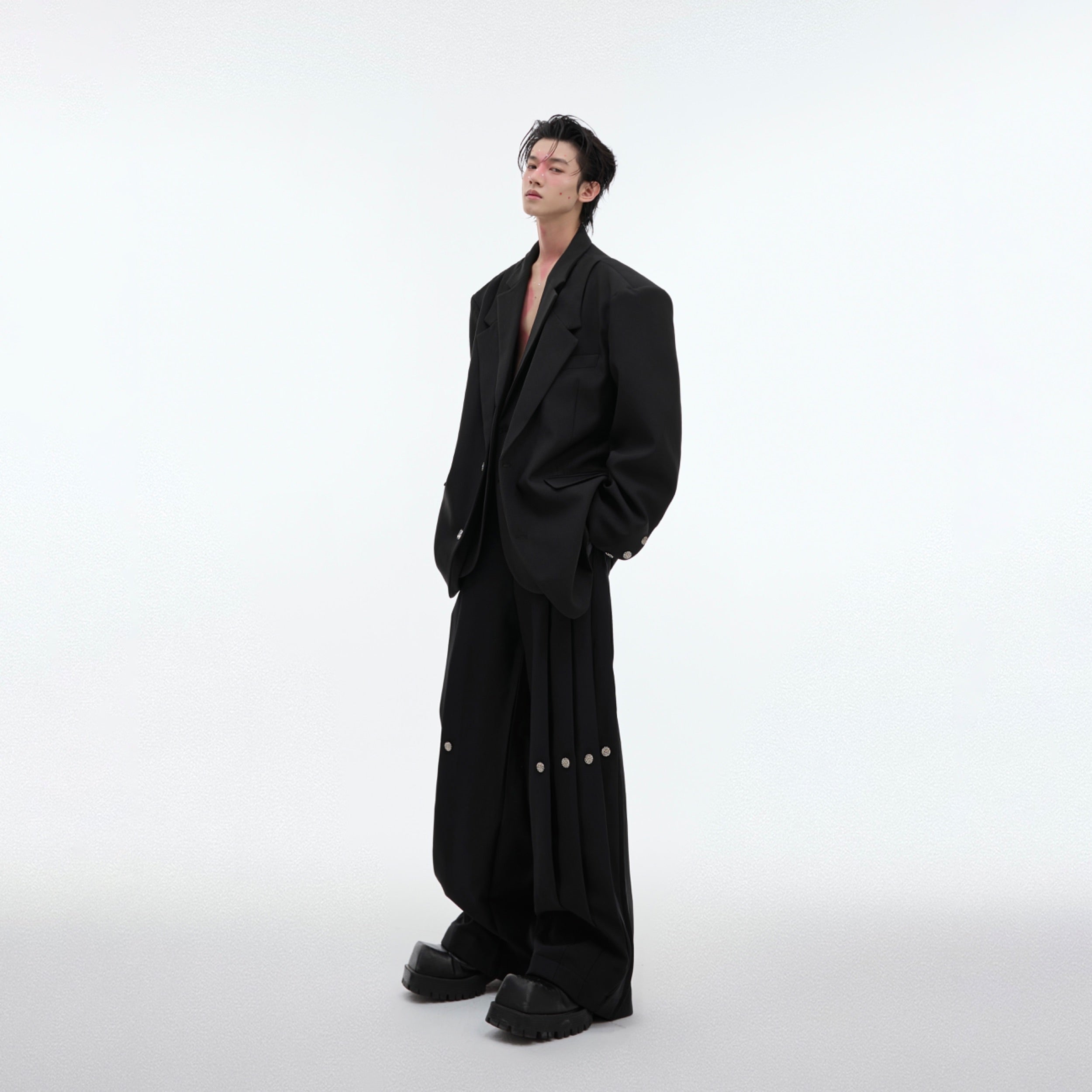 Deconstructed suit pants with pleated waist and unconventional tailoring for radical style