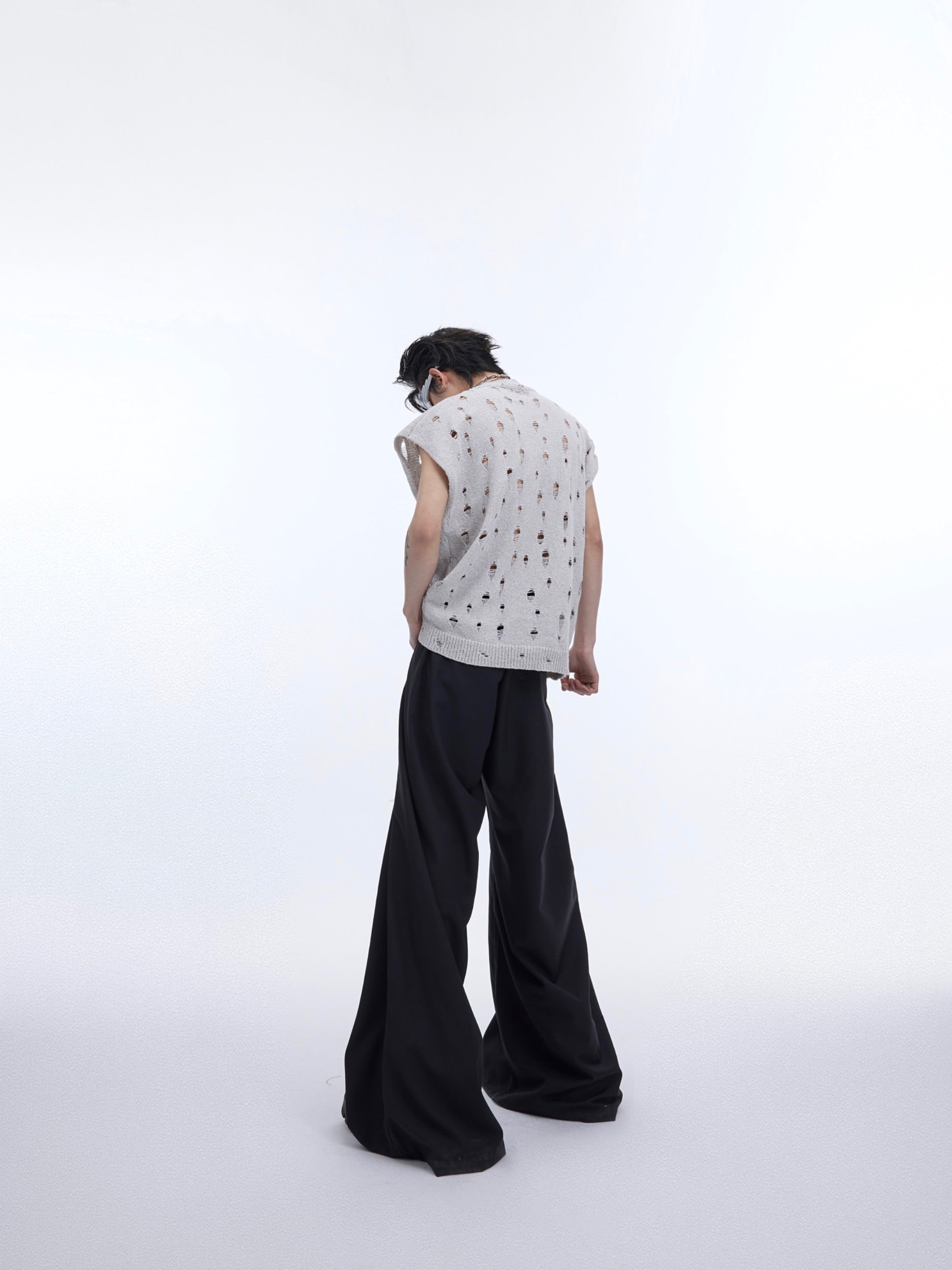Layering detail of the distressed metallic tank top with sheer cape for edgy streetwear looks