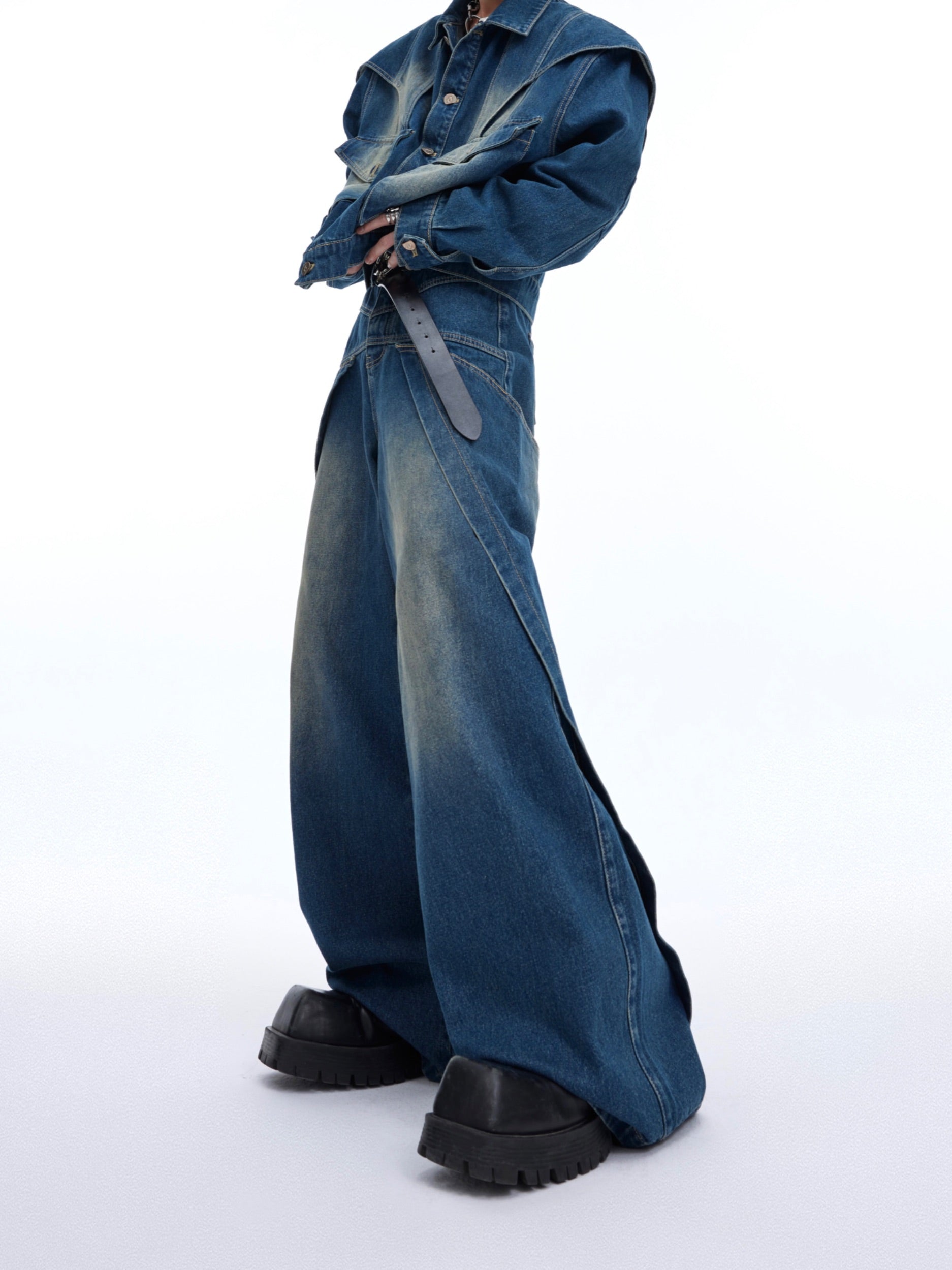 Close-up back view of cropped denim jacket showing raw edge deconstructed design elements