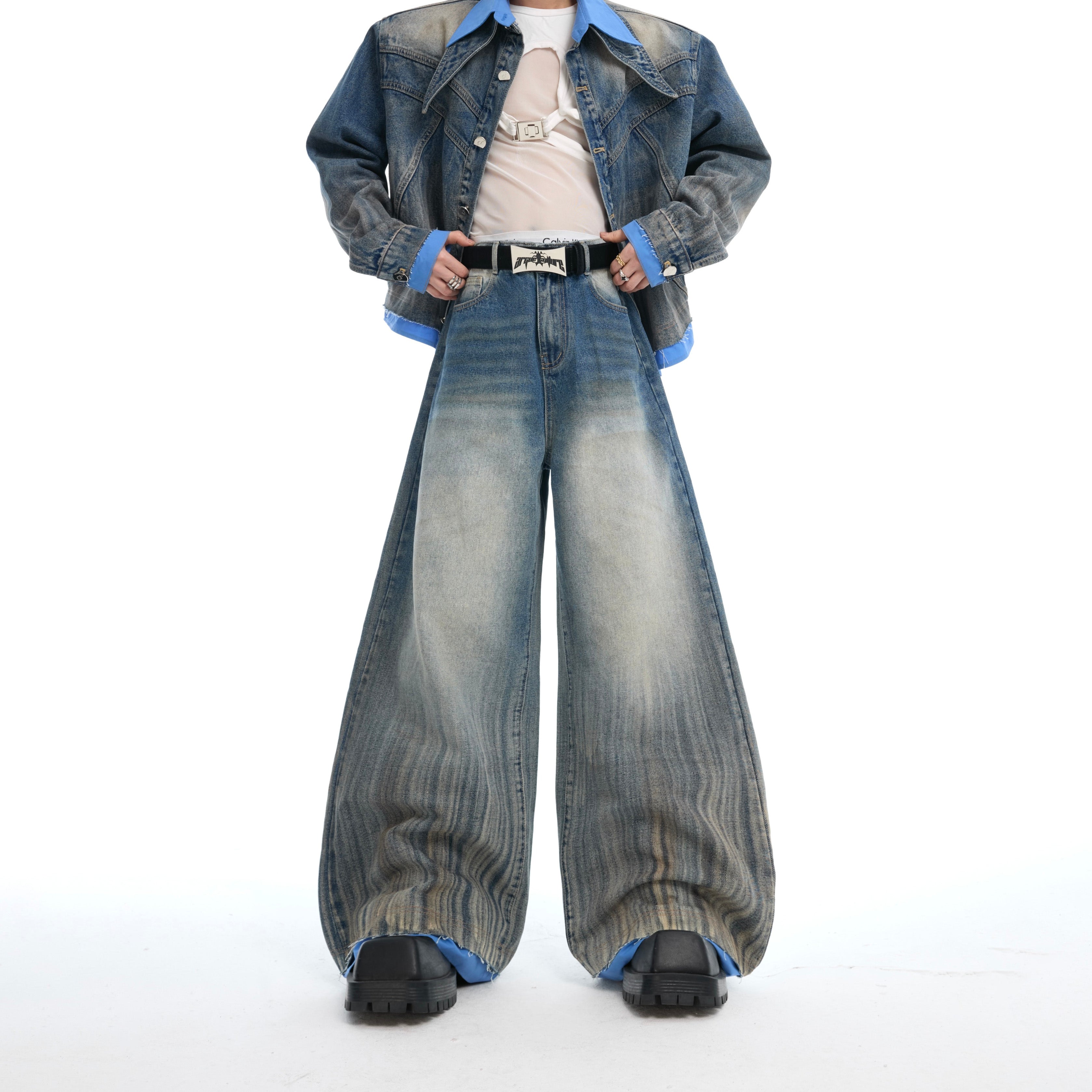 Back view showing the artisan patchwork design and faux two-piece construction of the denim jacket