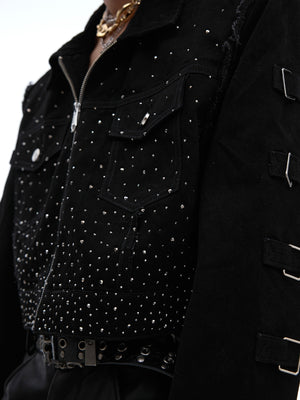 Close-up of distressed denim jacket with structured shoulder pads and hybrid fabric blend texture