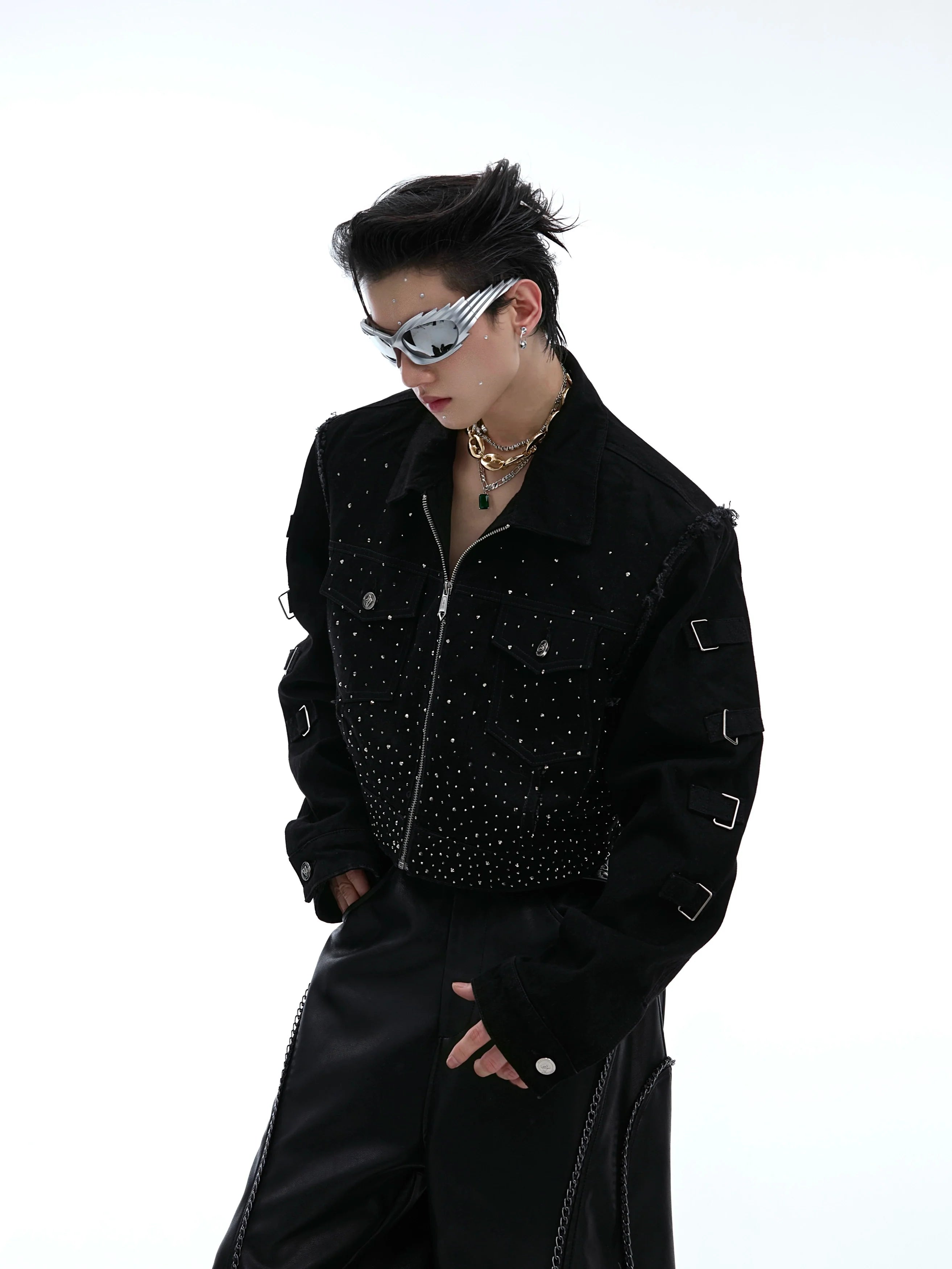 Cropped distressed denim jacket with shoulder pads and rhinestone detailing, showcasing avant-garde streetwear style