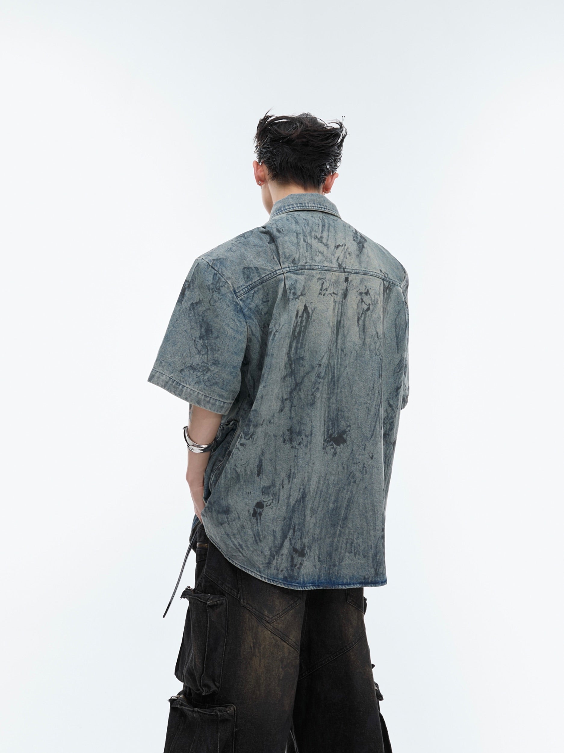 Close-up of the premium distressed denim fabric and hand-painted artistic details on this streetwear top