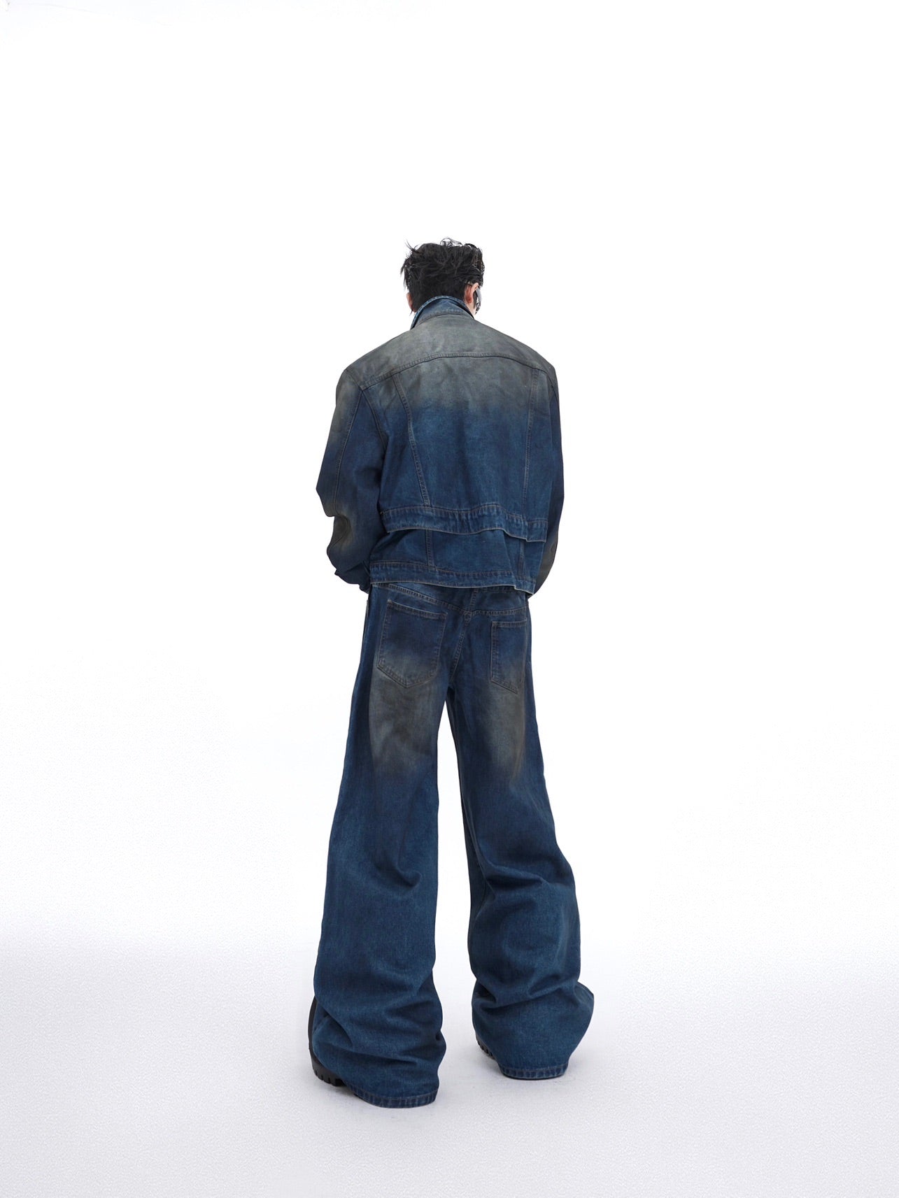 Close-up of back detailing on distressed denim jacket showing unique distressing patterns and stitching