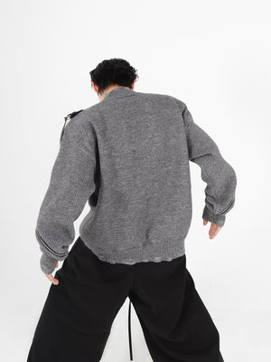 Stylish distressed knit cardigan shown as a layering piece with the zipper partially open for casual wear