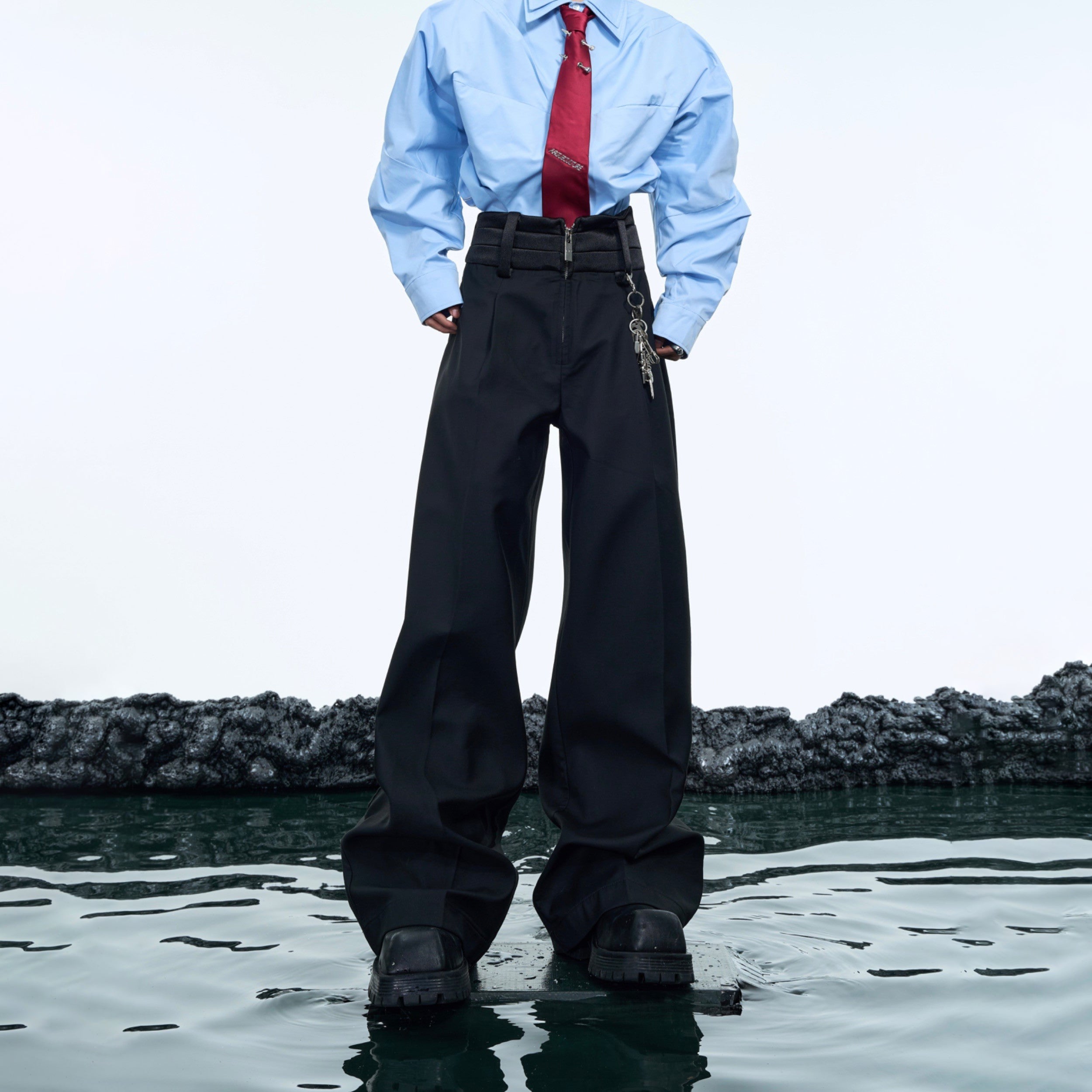 Front view of high-waisted flare pants with unique double-layer construction, showcasing minimalist solid design