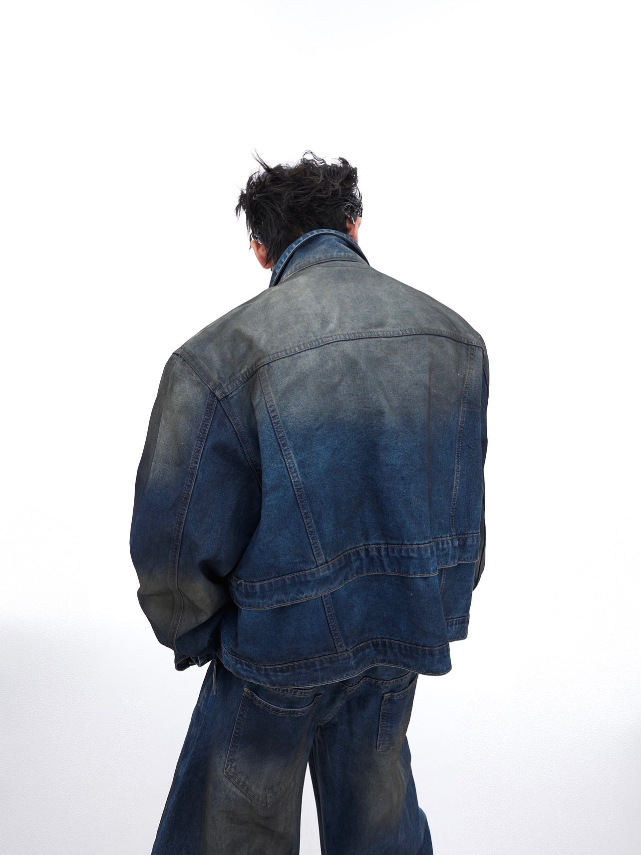Detail shot showing the double-layer construction and premium denim fabric of distressed jacket