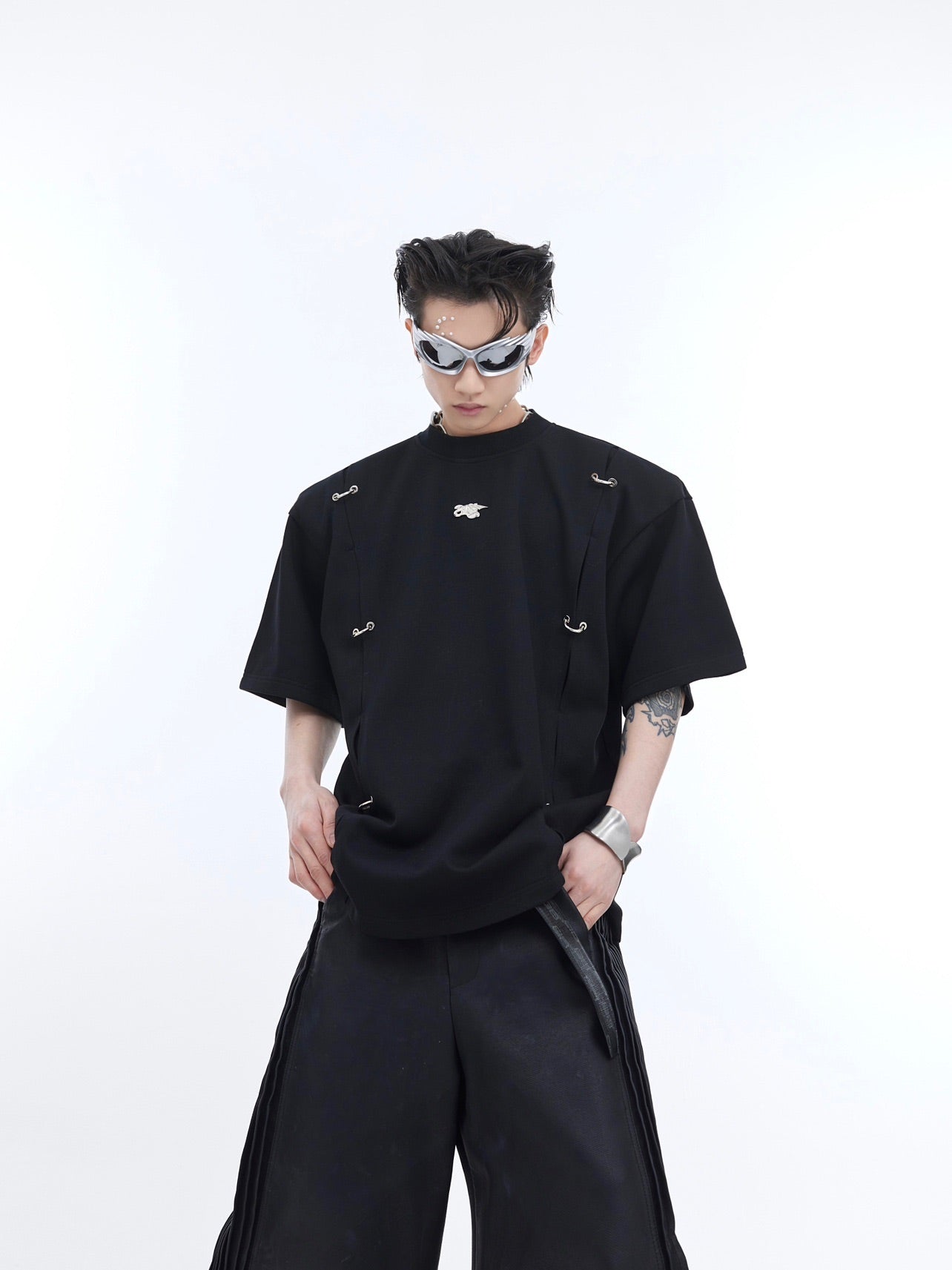 Close-up of avant-garde metal detailing on deconstructed drop-shoulder streetwear t-shirt