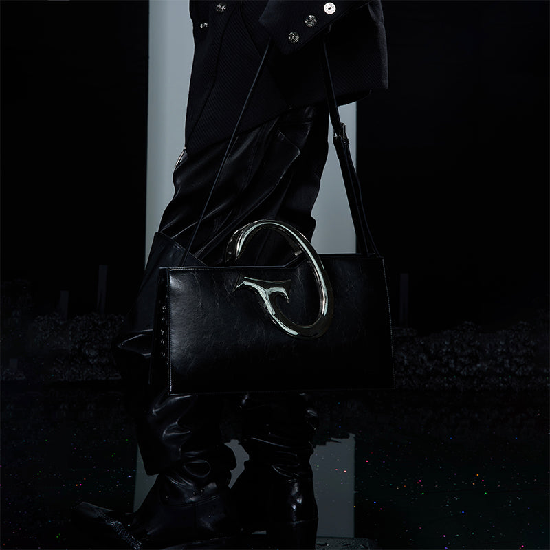Unique asymmetrical crossbody bag with metal chain accents for a bold fashion statement
