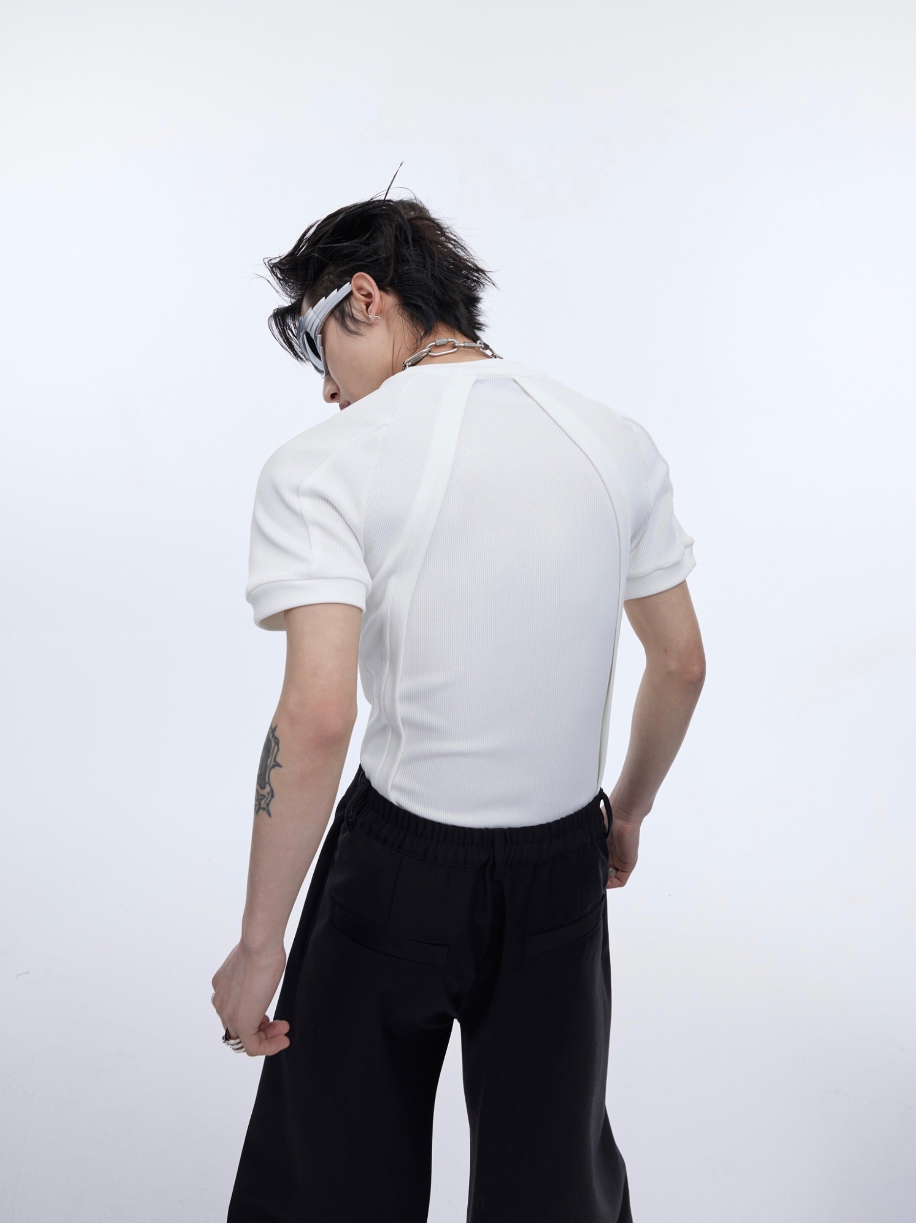 Side detail shot highlighting the unconventional stitching and deconstructed elements of this gender-neutral slim-fit top