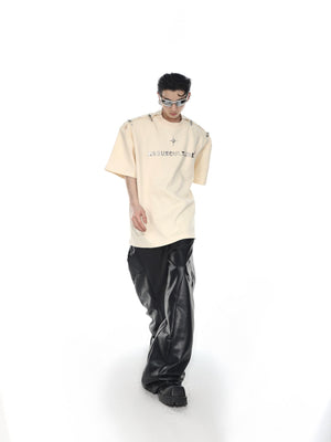 Model wearing deconstructed streetwear tee with statement shoulder pads and metal hardware