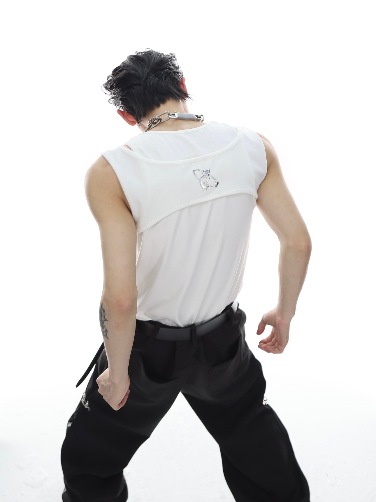 Close-up of the innovative metal buckle detail on this fashion-forward deconstructed tank top