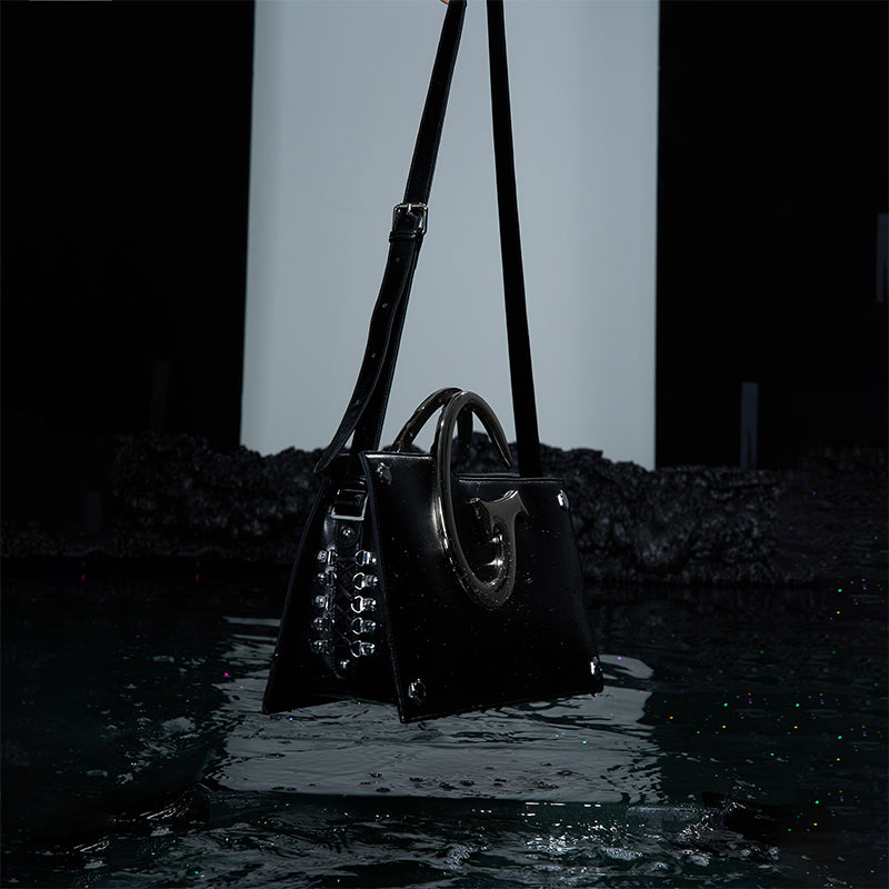 Trendsetting shoulder bag with asymmetrical shape and premium metal chain handle details