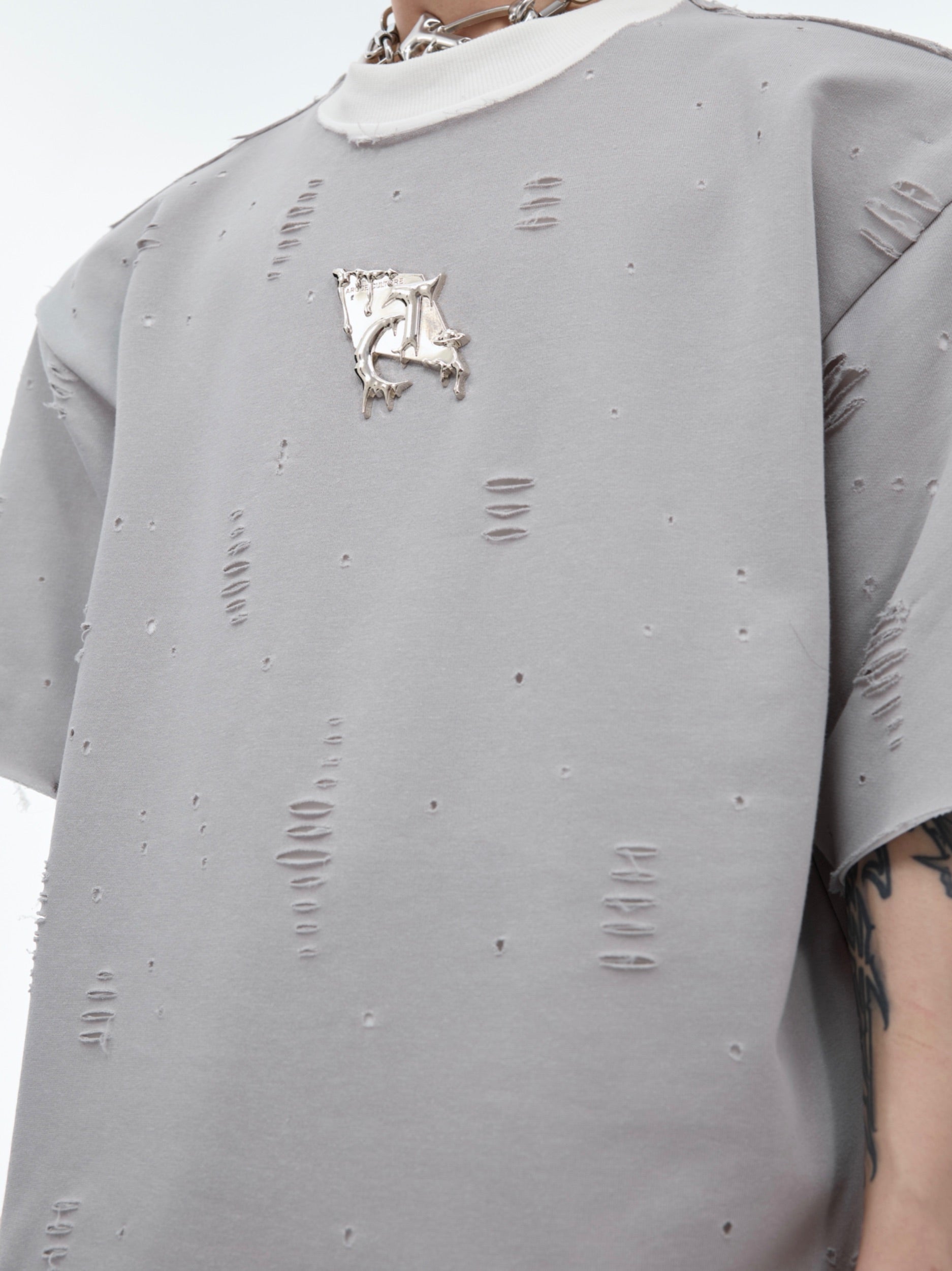 Side angle showing the faux two-layer construction and distressed hem details of this unique oversized tee