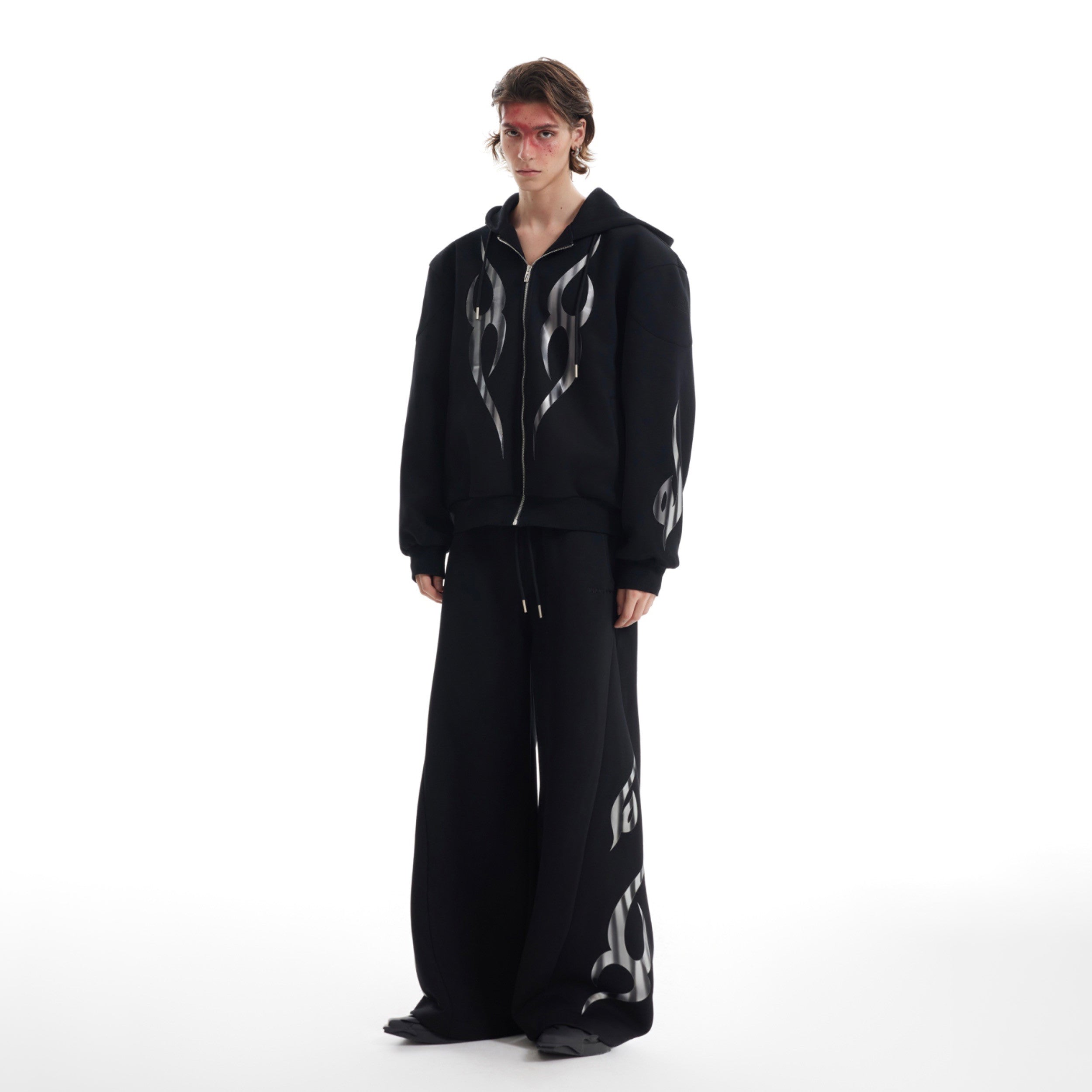 Side angle of deconstructed flame hoodie showing extended sleeves and oversized streetwear silhouette